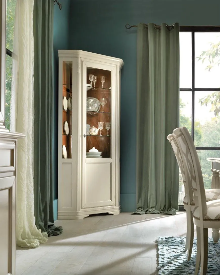 Angoliera avorio Trend Style Imba con anta a vetro in una sala con pareti verde petrolio