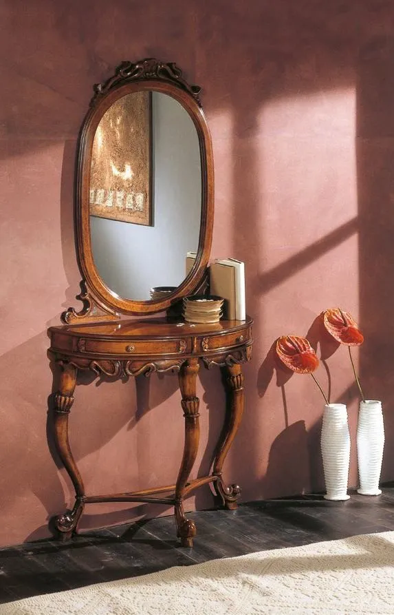 Consolle Trend Style Imba in noce intagliato sotto uno specchio ovale davanti a una parete rosa