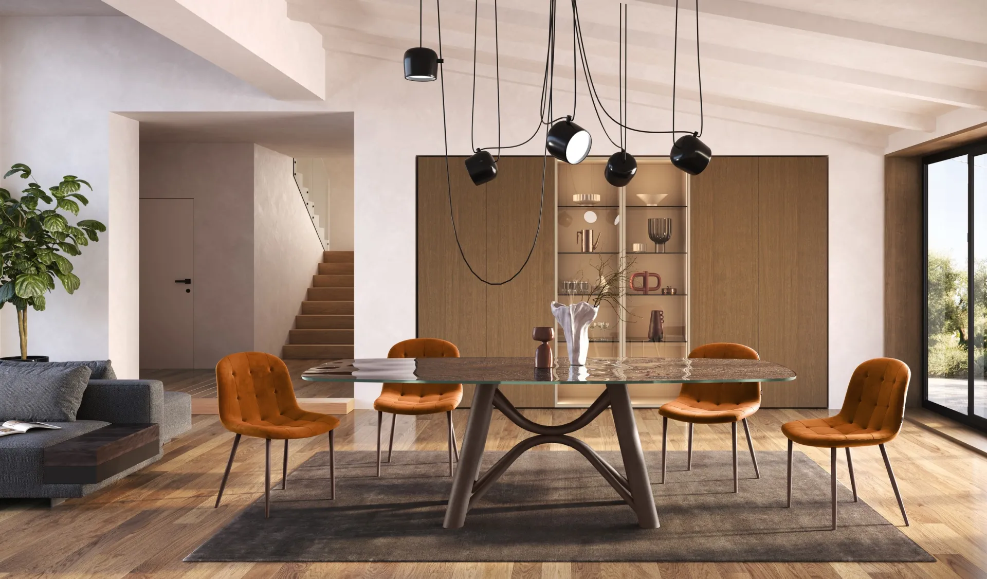 Tavolo Brooklin Scavolini con piano in vetro e sedie color ruggine sotto lampade a sospensione