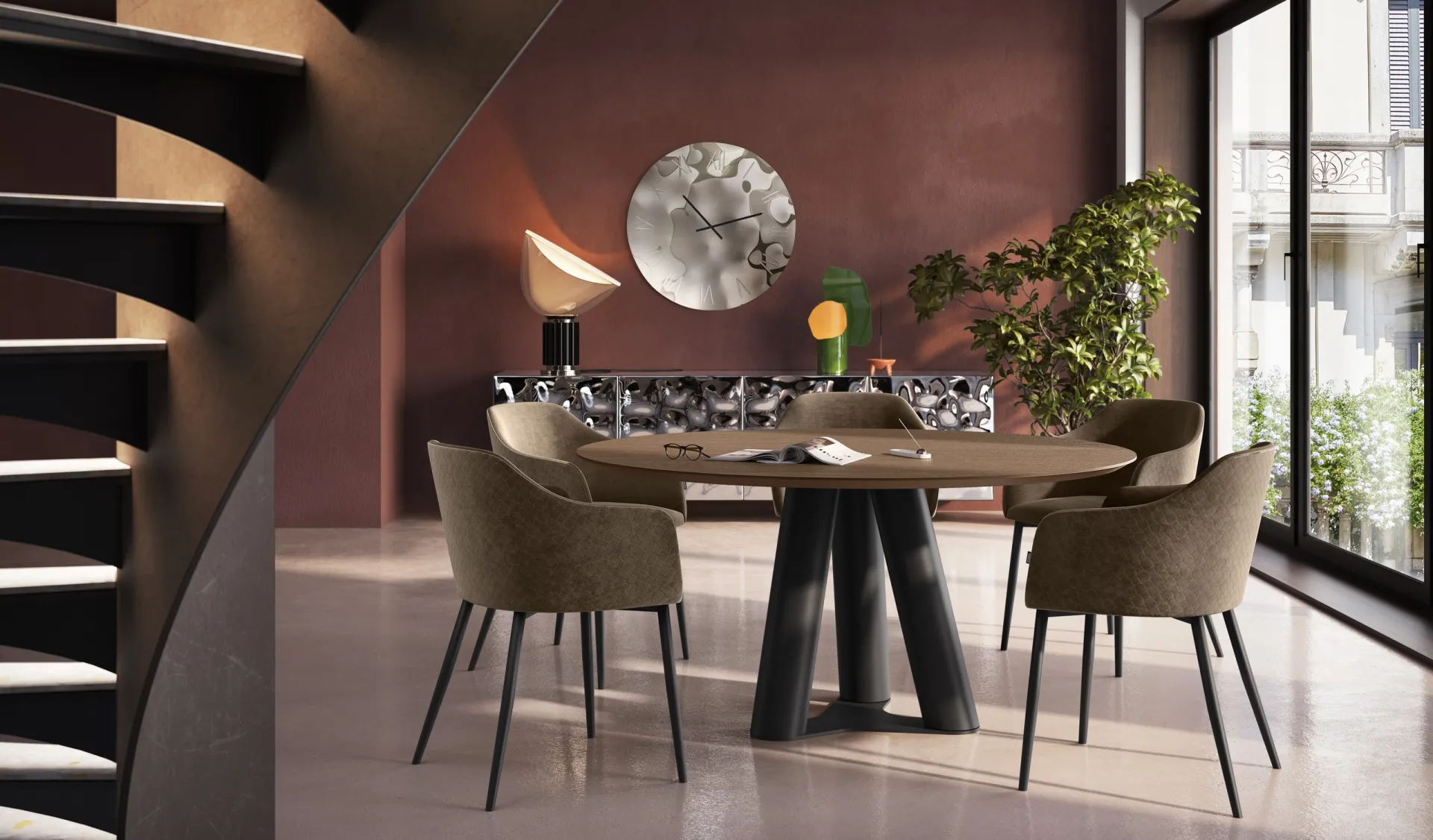 Tavolo Singapore Scavolini rotondo in legno scuro con poltroncine verde salvia e scala a chiocciola