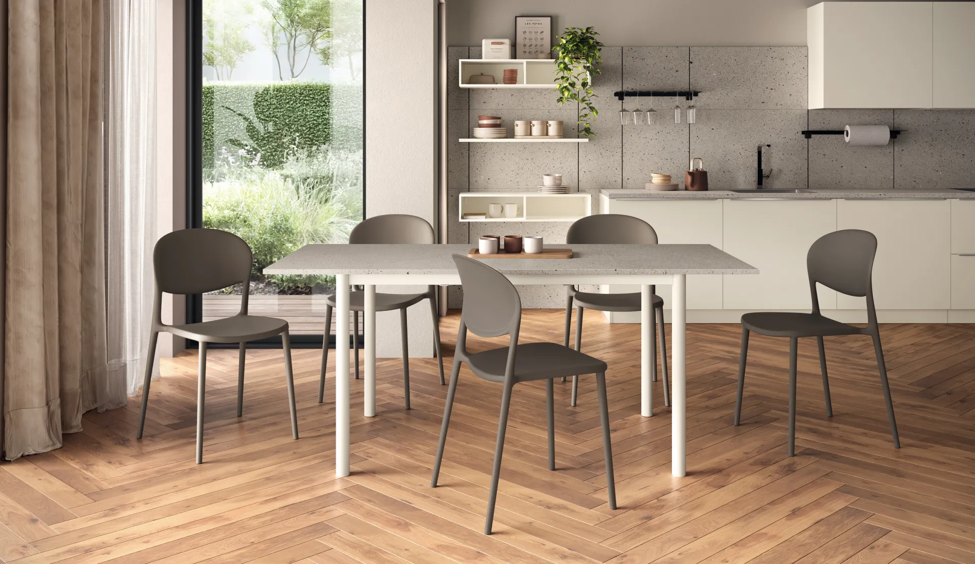 Tavolo Message Scavolini con piano chiaro, gambe bianche e sedie grigie accanto a una cucina chiara