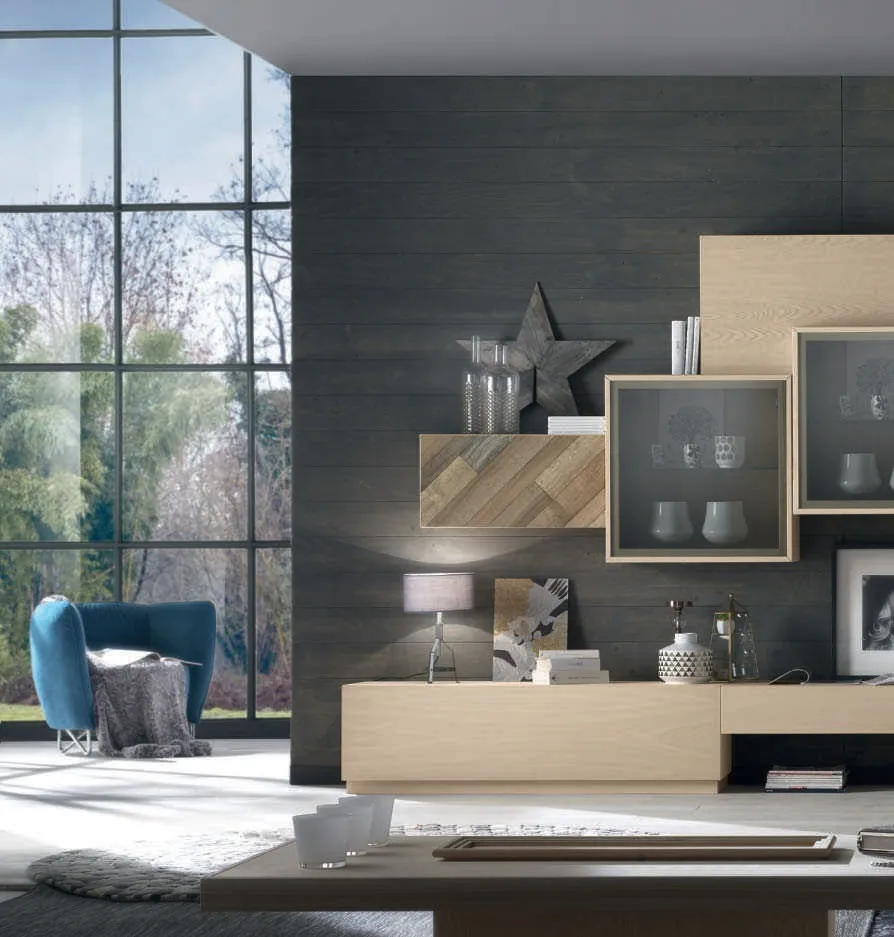 Parete House Project Imba in frassino chiaro con mensole e base, accanto a una poltrona blu