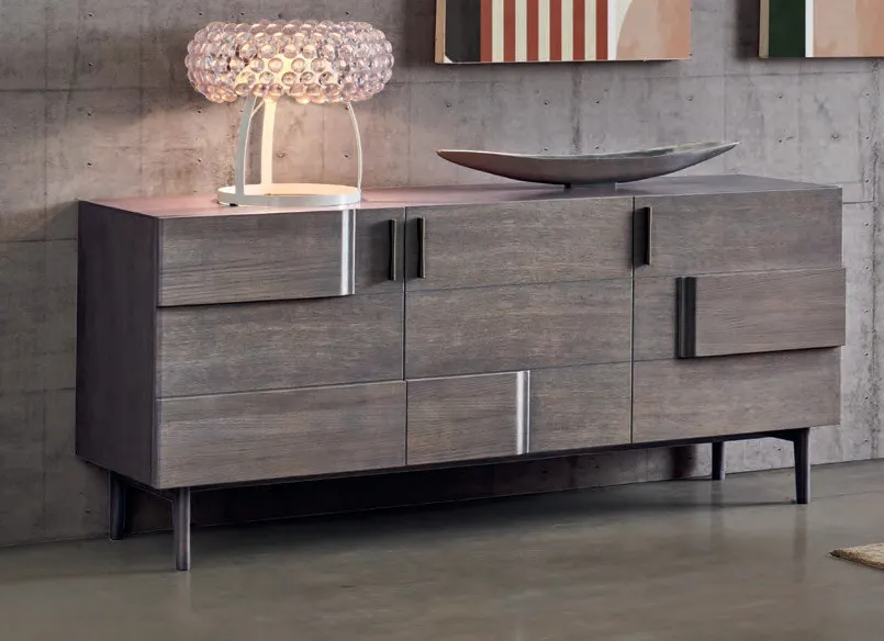 Credenza Marte Imba grigia con maniglie metalliche sotto un lampadario