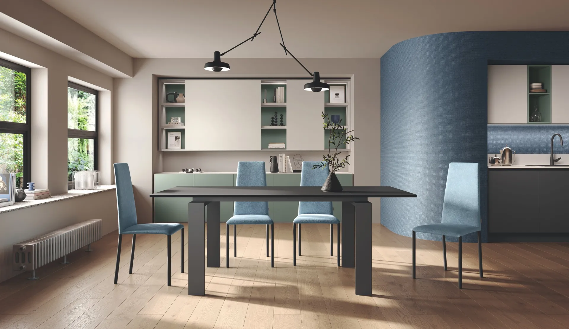 Tavolo Letter Scavolini scuro allungato con sedie azzurre in una zona pranzo aperta sulla cucina