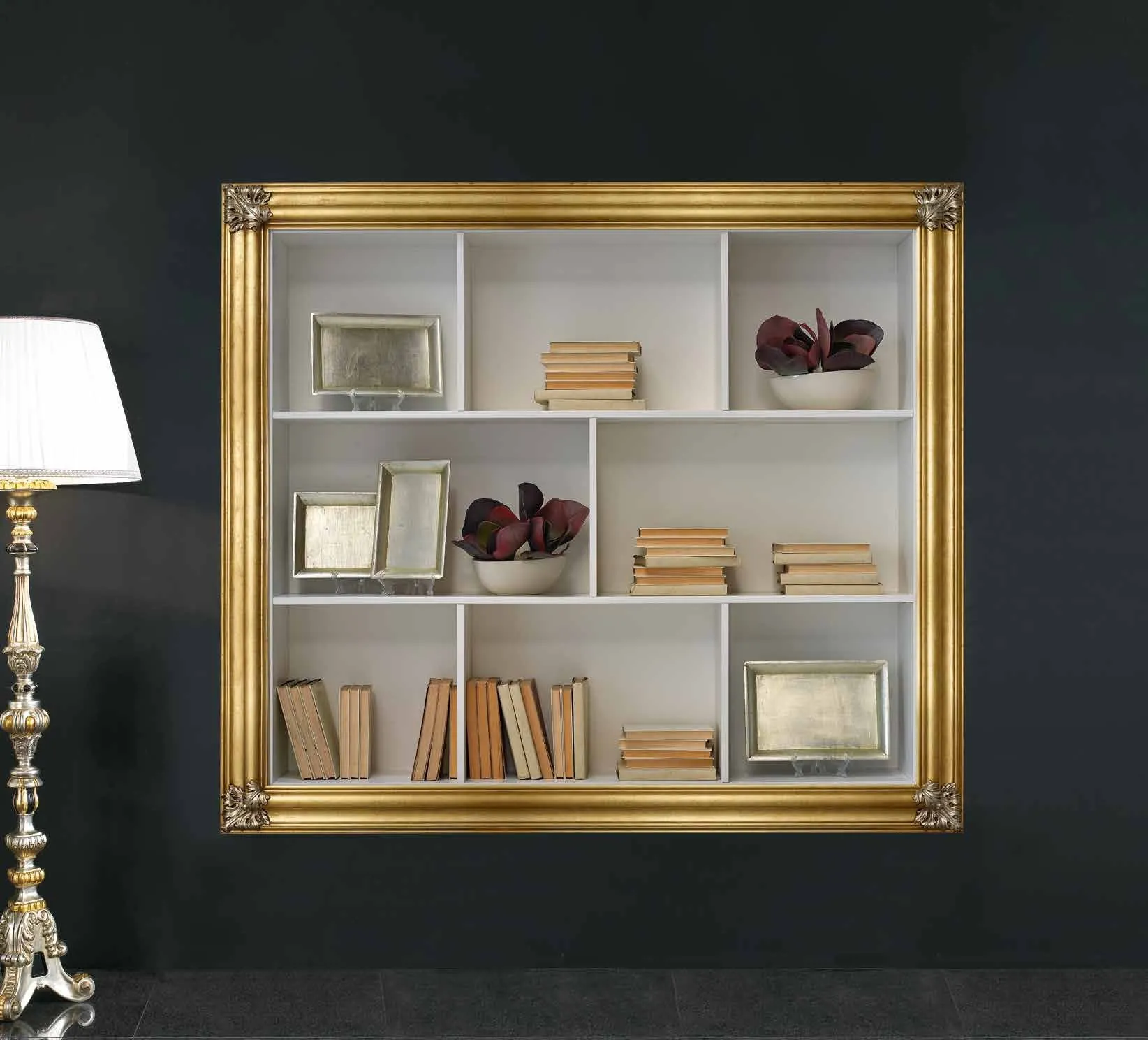 Cornice LI 1030 Imba dorata con mensole e libri, accanto a una lampada a stelo