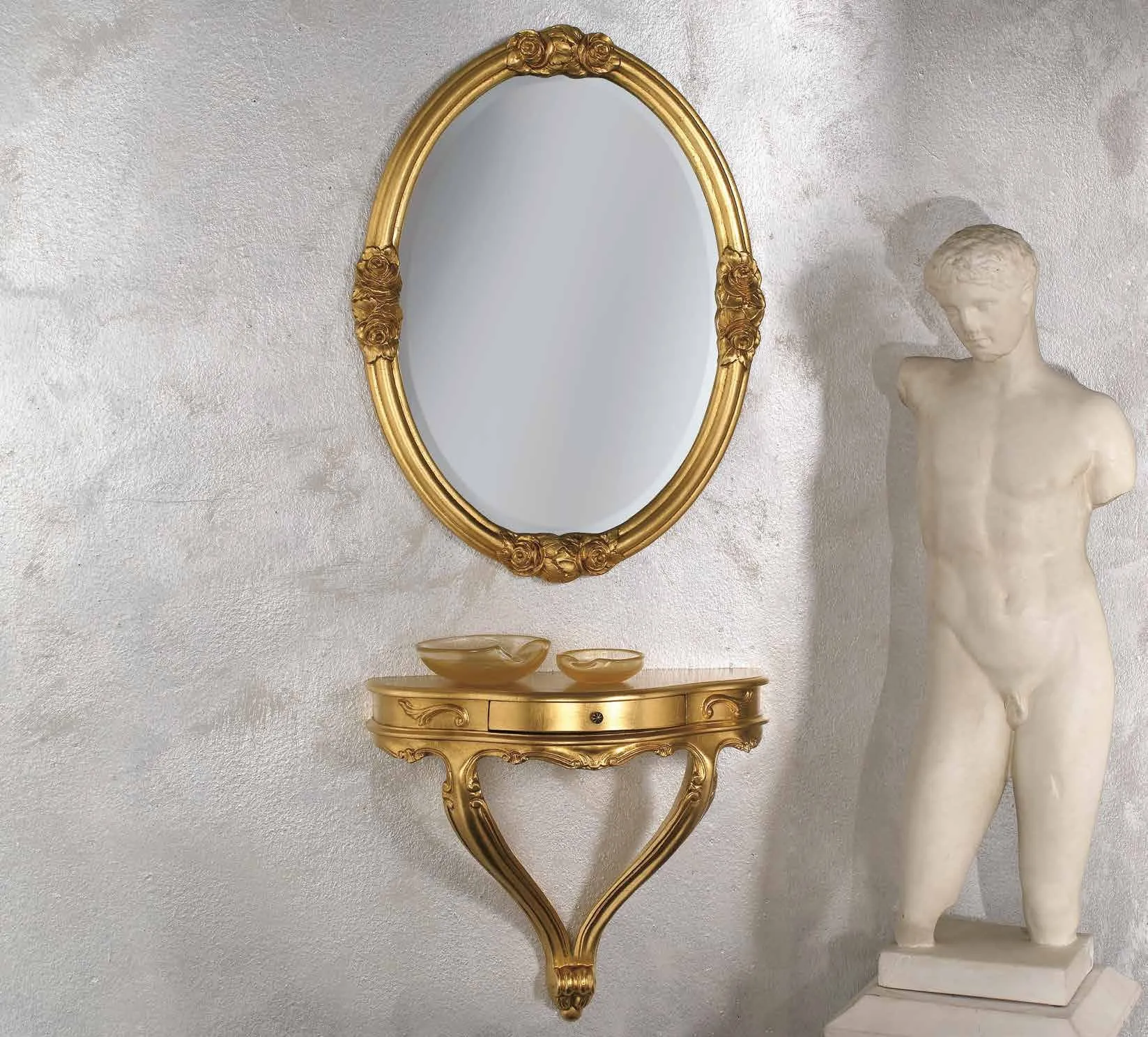 Consolle pensile PL 5020 e specchio ovale PL 5021 Imba dorati accanto a una statua