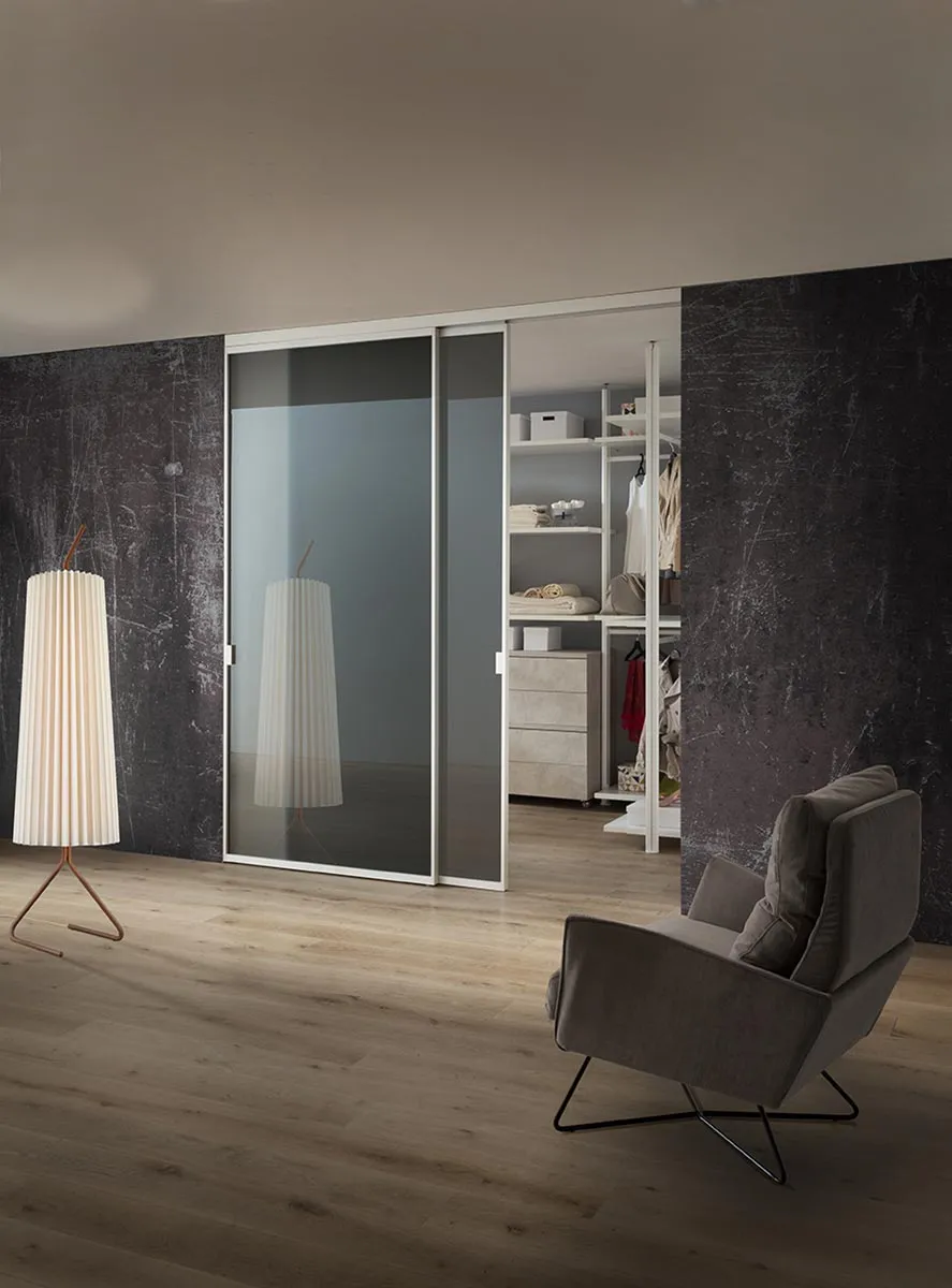 Porte scorrevoli Naike La Primavera in vetro davanti a una cabina armadio