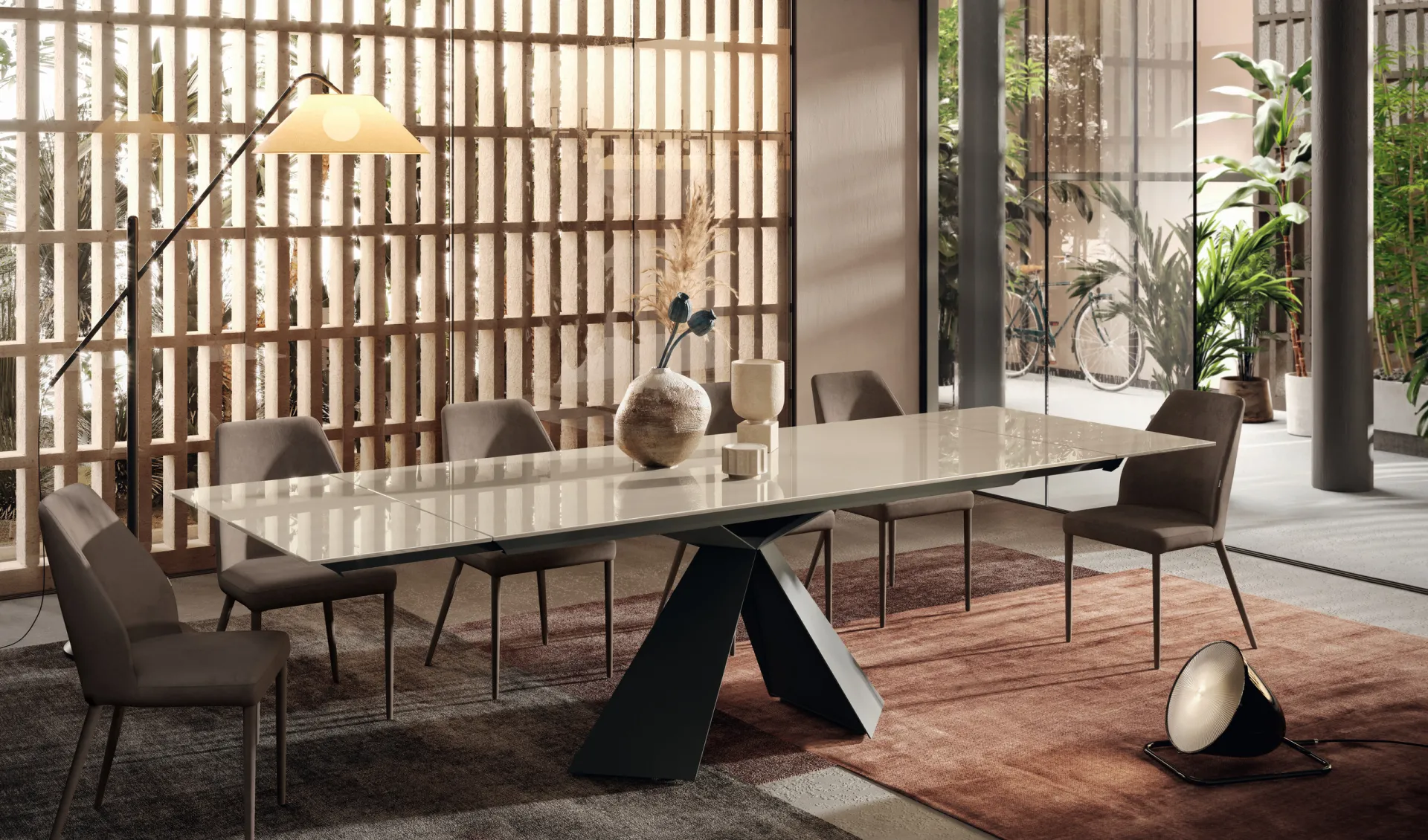Tavolo Metropolis Scavolini con piano chiaro lungo e sedie grigie davanti a una parete di listelli