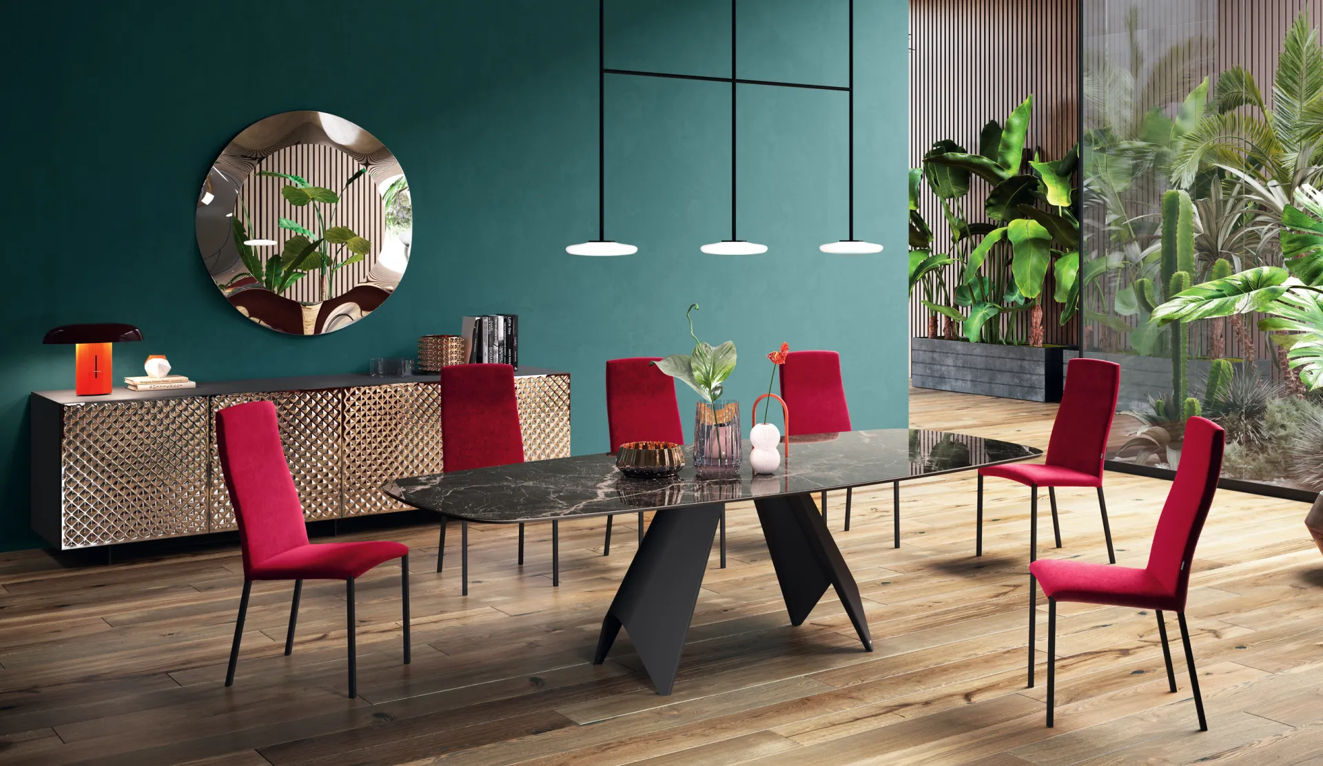 Tavolo Luxor Scavolini con piano scuro venato, sedie rosse e parete verde petrolio