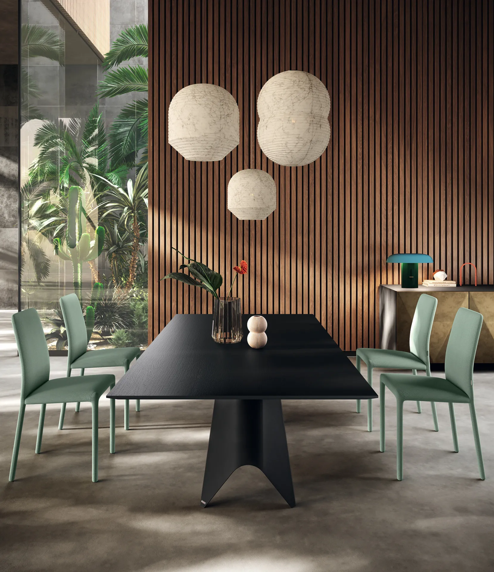 Tavolo Luxor Scavolini con piano nero opaco e sedie verde salvia davanti a una parete in legno