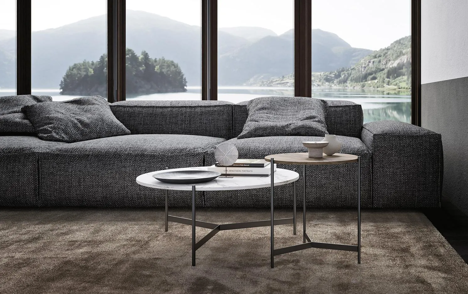 Tavolini rotondi Toor MobilGam davanti a divano grigio con vista lago