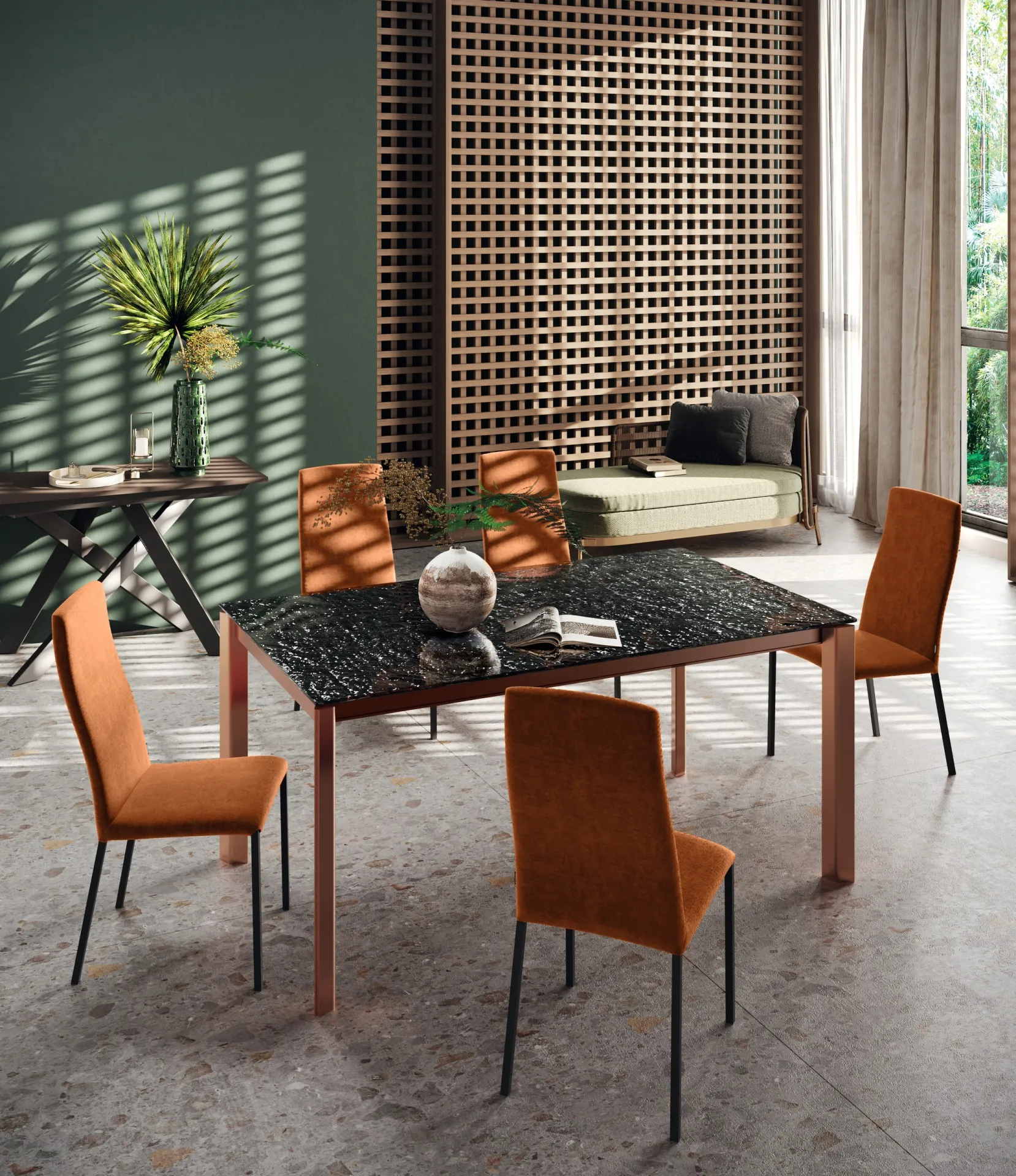 Tavolo Cosmic Scavolini con piano nero venato, gambe color rame e sedie arancioni
