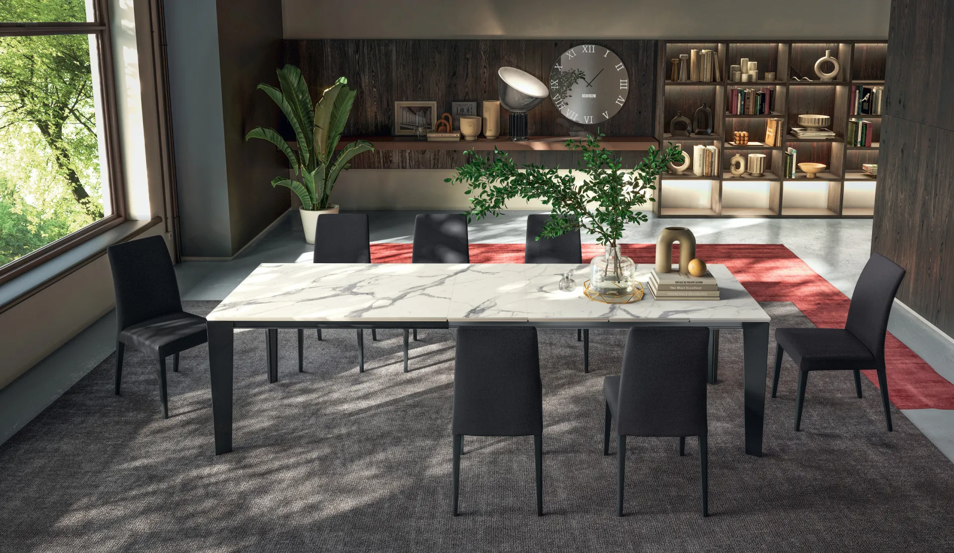 Tavolo Infinity Scavolini con piano effetto marmo bianco e sedie nere in un soggiorno con libreria