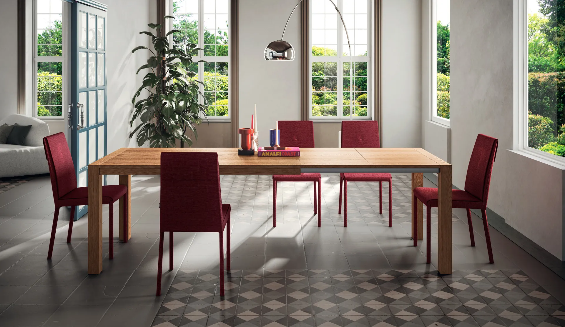 Tavolo Context Scavolini in rovere invecchiato con sedie rosse in una sala con pavimento in cementine