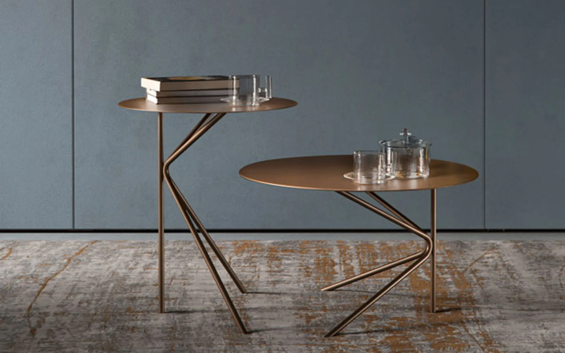 Tavolini Twin Rosini color bronzo davanti a una parete blu