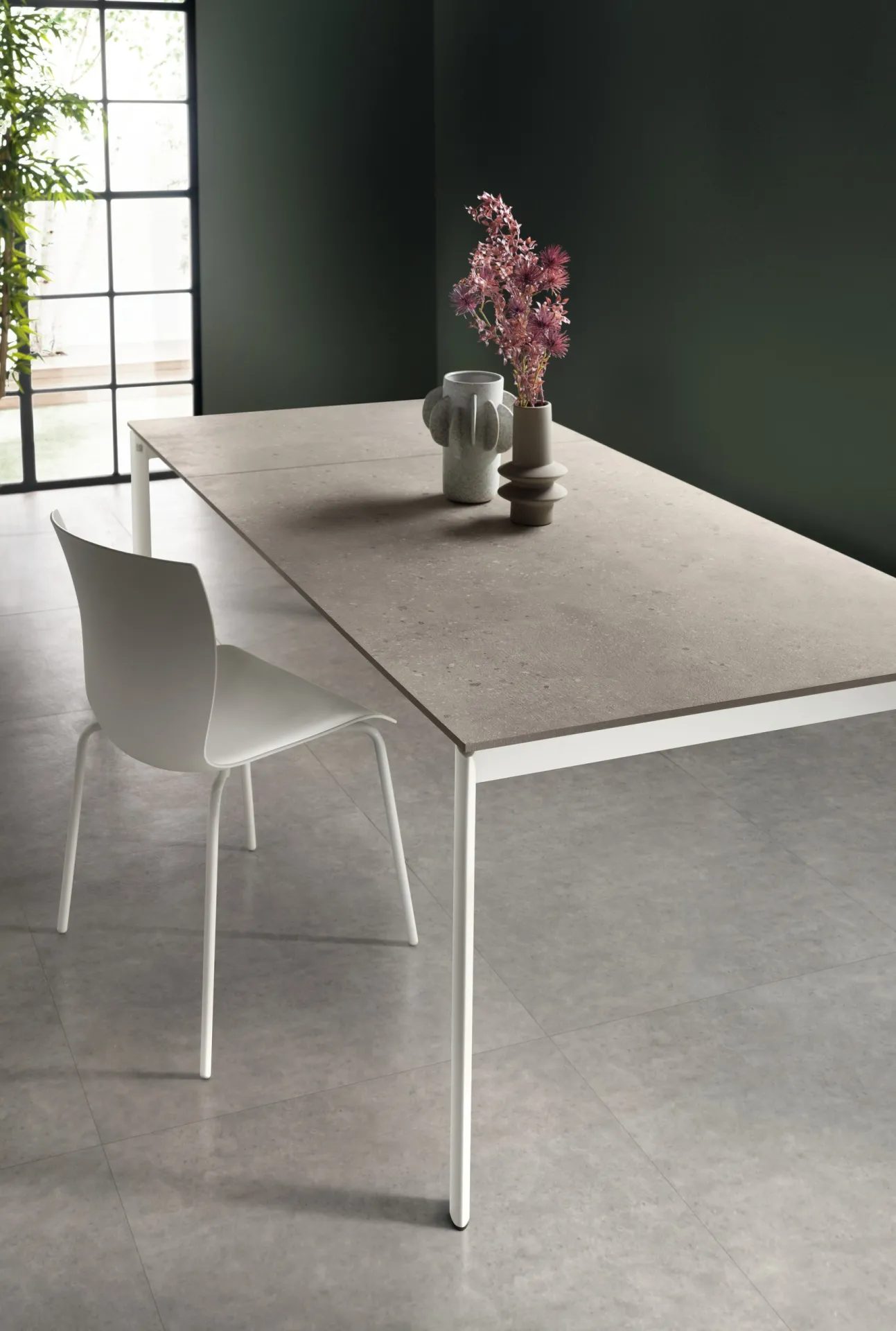 Tavolo Aiko Scavolini allungato con piano grigio chiaro e gambe bianche in metallo