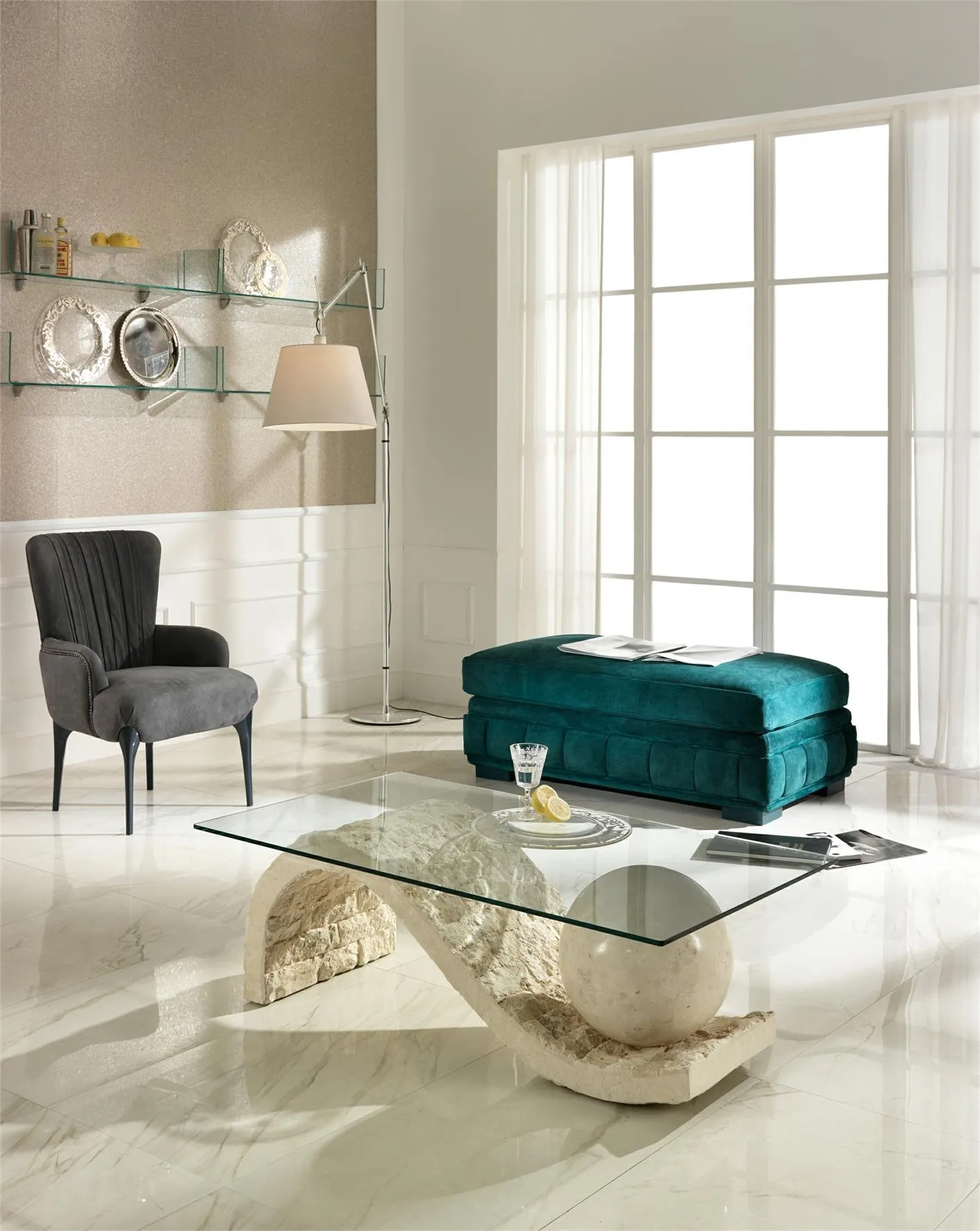 Tavolino Onda Stones con piano in vetro in un salotto con poltrona nera e pouf verde