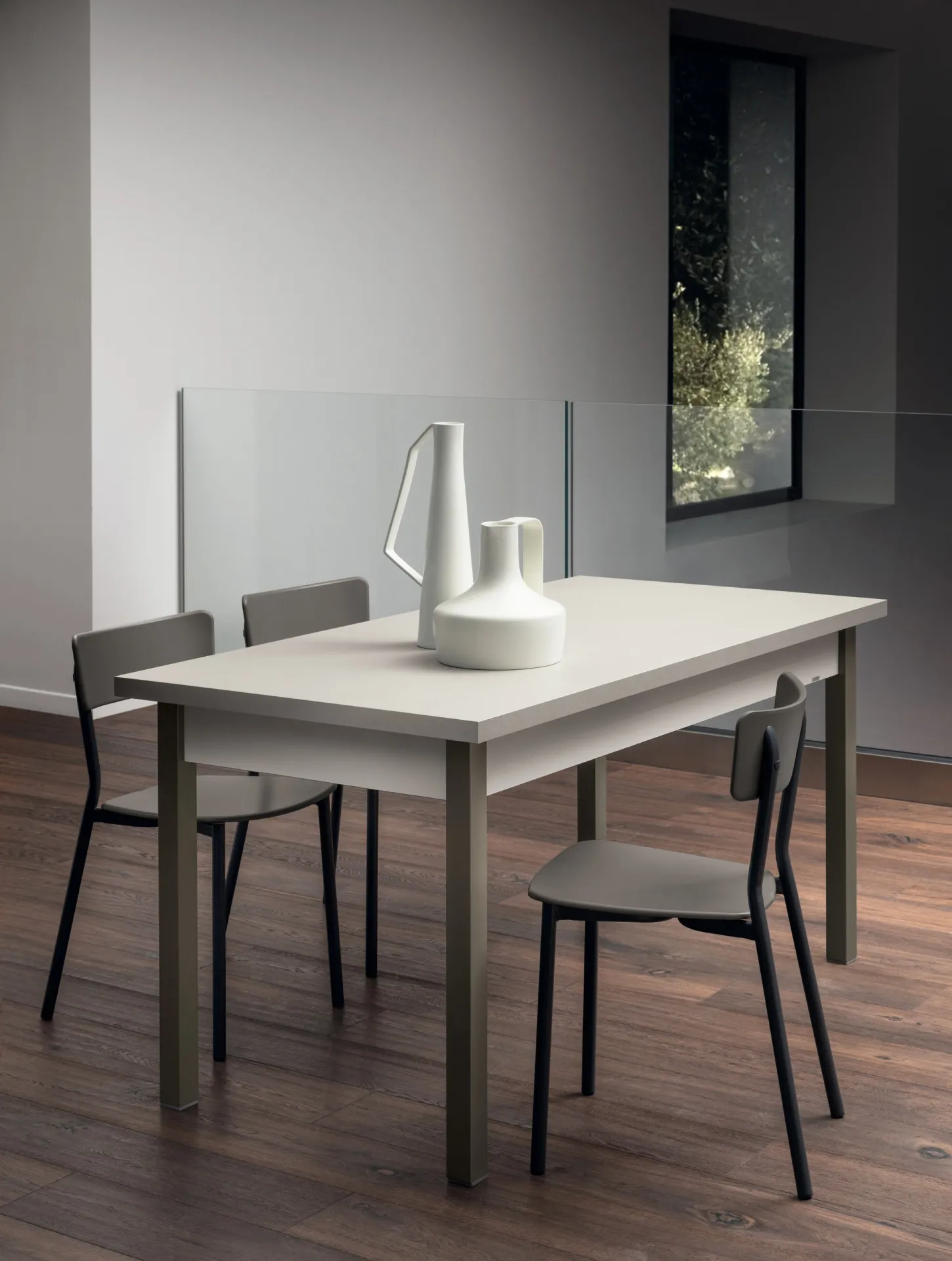 Tavolo Alis Scavolini con piano bianco, gambe grigio tortora e due sedie in una cucina