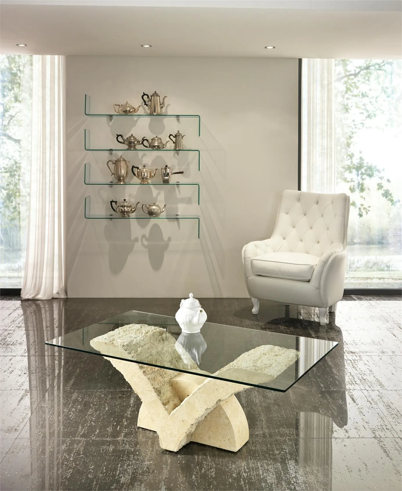 Tavolino Papillon Stones in pietra beige davanti a una poltrona bianca