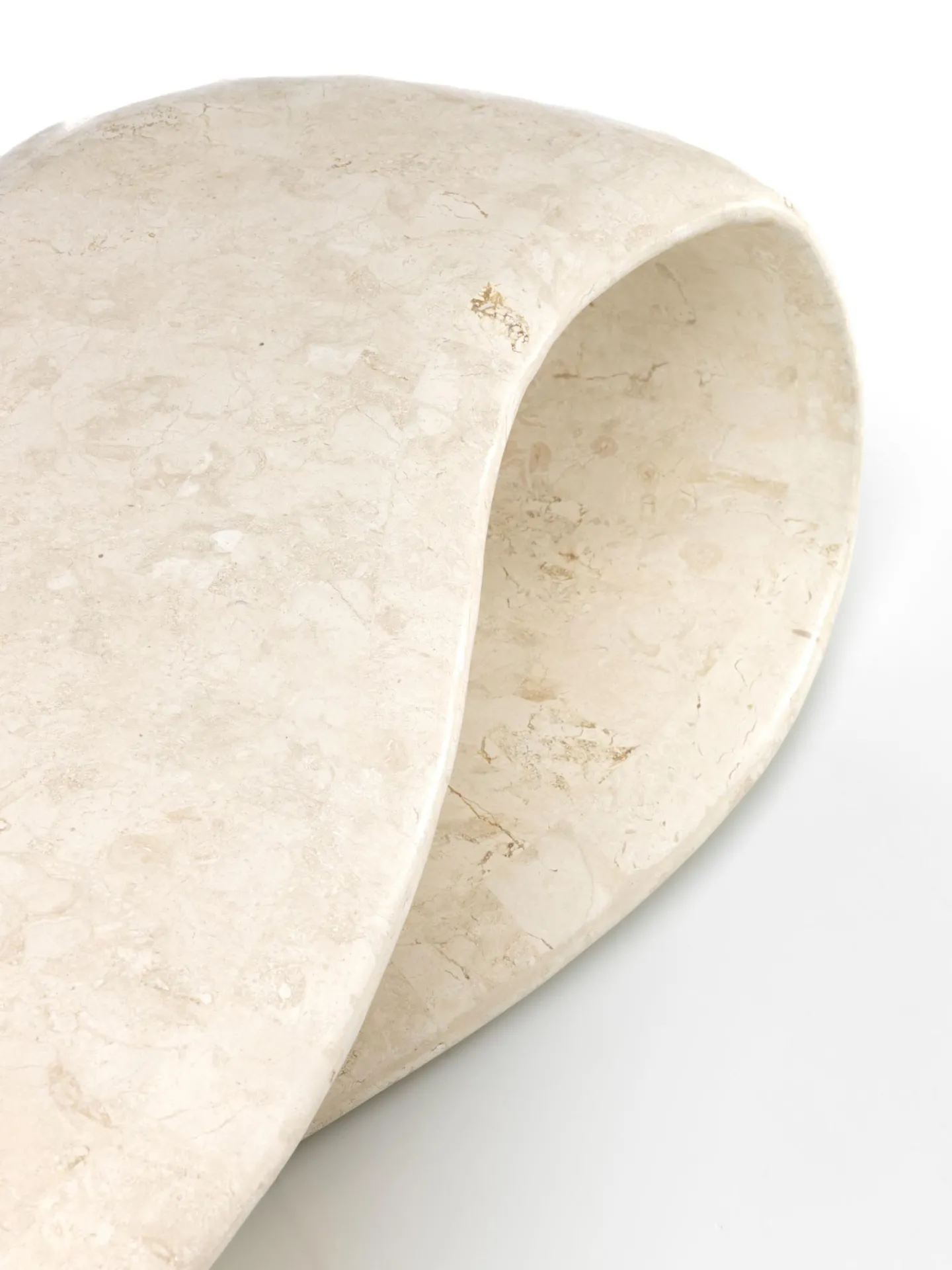 Dettaglio della curva in pietra beige del tavolino Scarf Stones