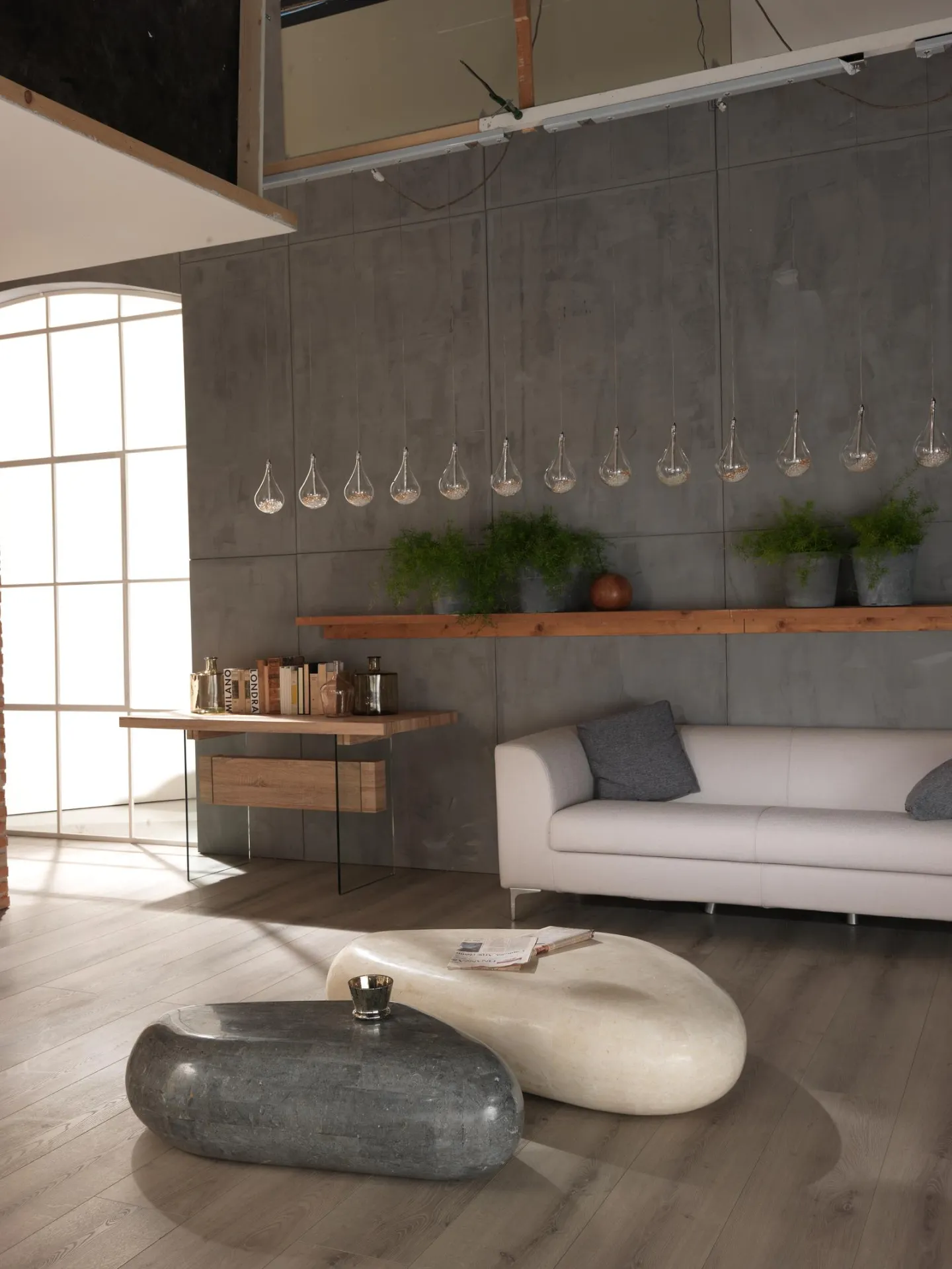 Tavolino Sasso Big Stones beige davanti a un divano bianco in un open space