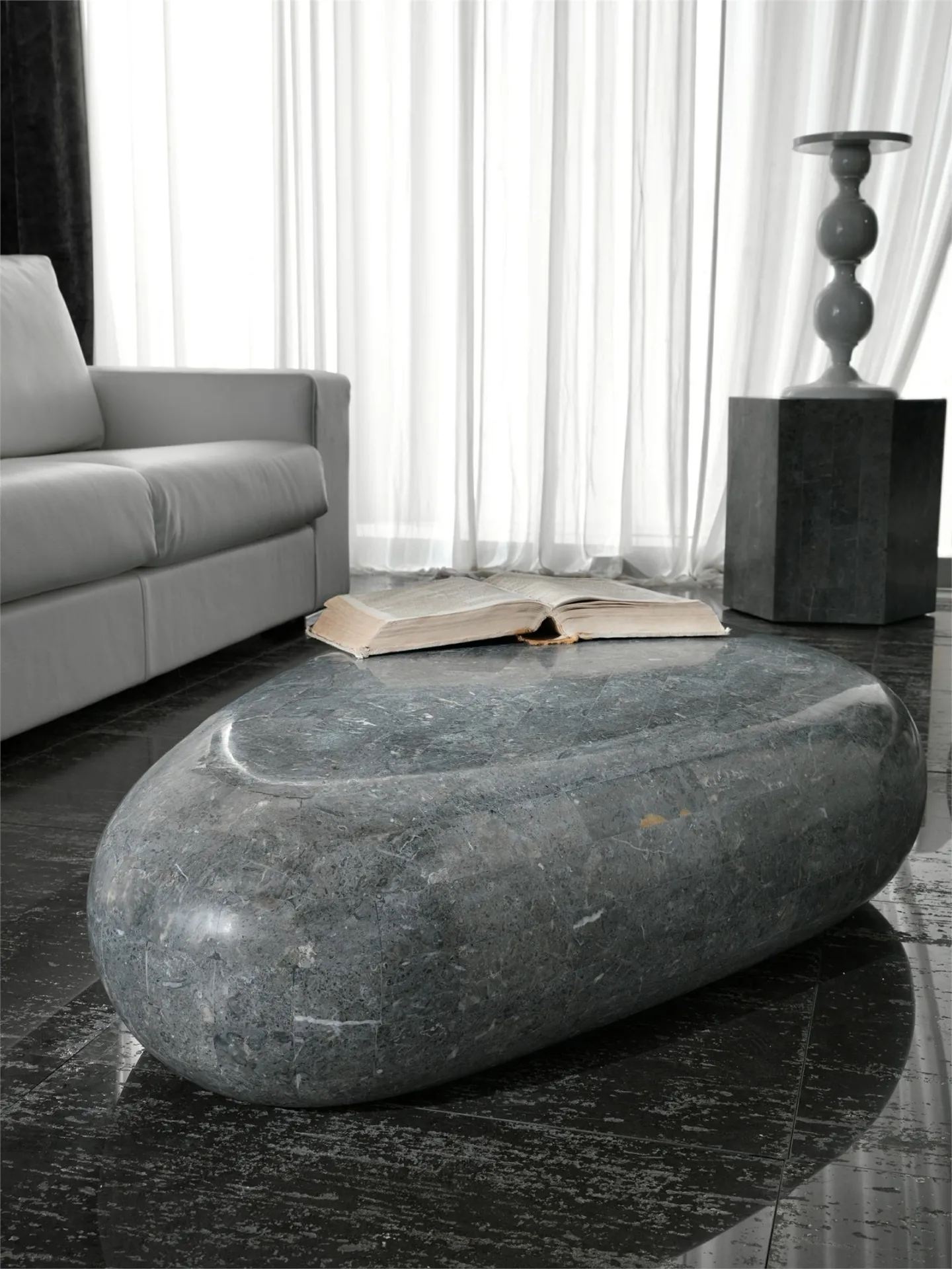 Tavolino Sasso Medium Stones grigio accanto a un divano chiaro