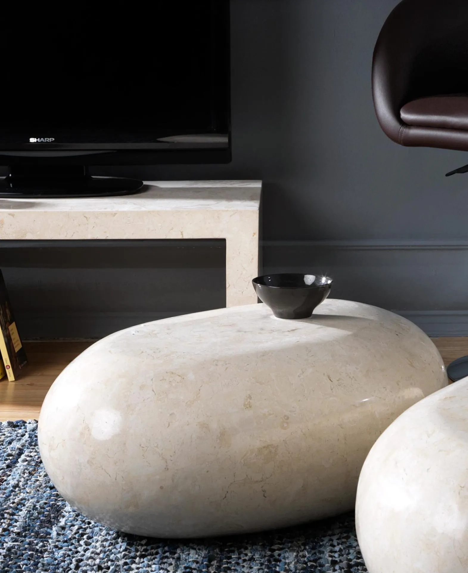 Tavolini Sasso Stones in pietra beige su un tappeto davanti alla TV