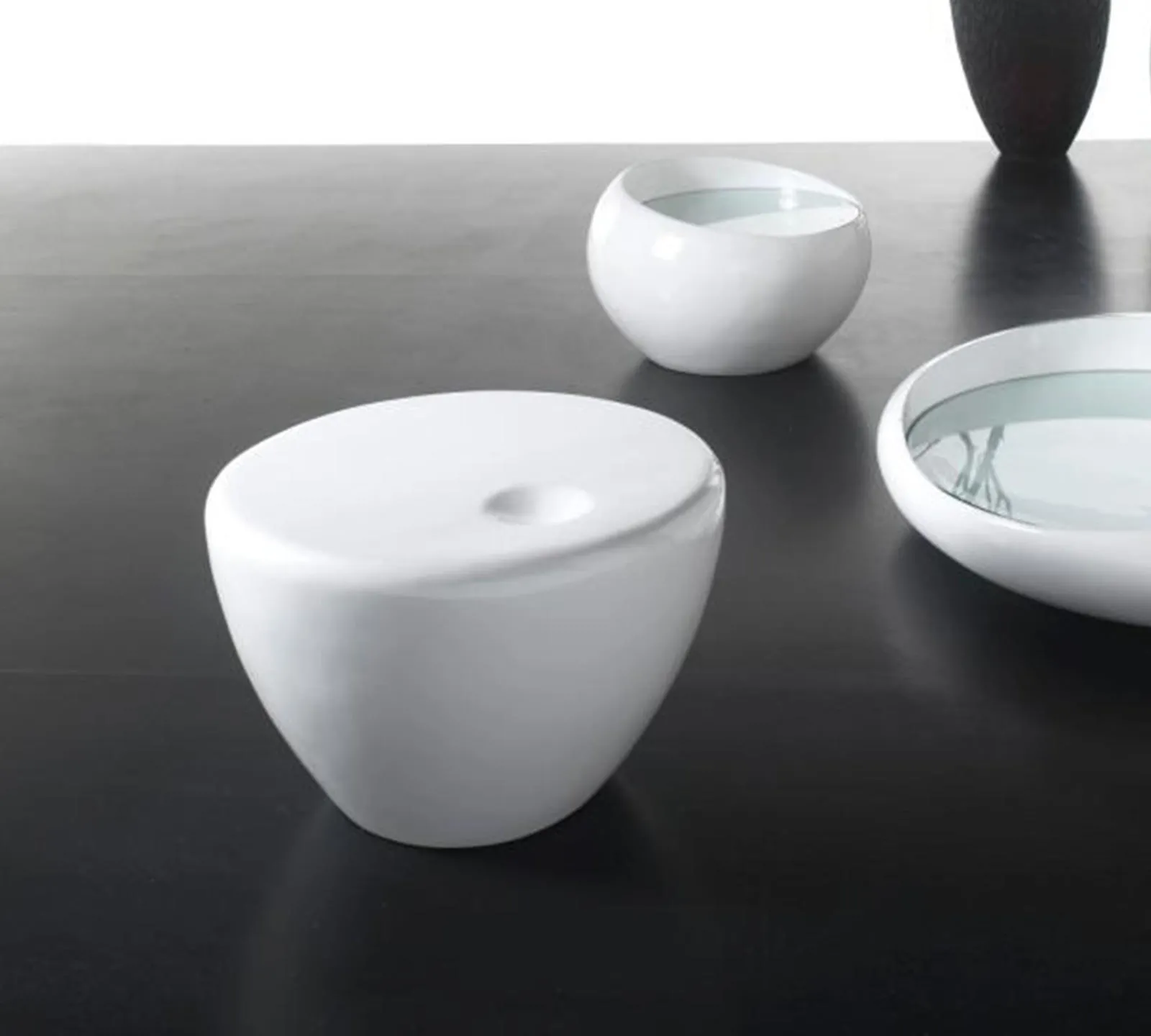 Tavolino Bowl Stones in resina bianca su un pavimento scuro