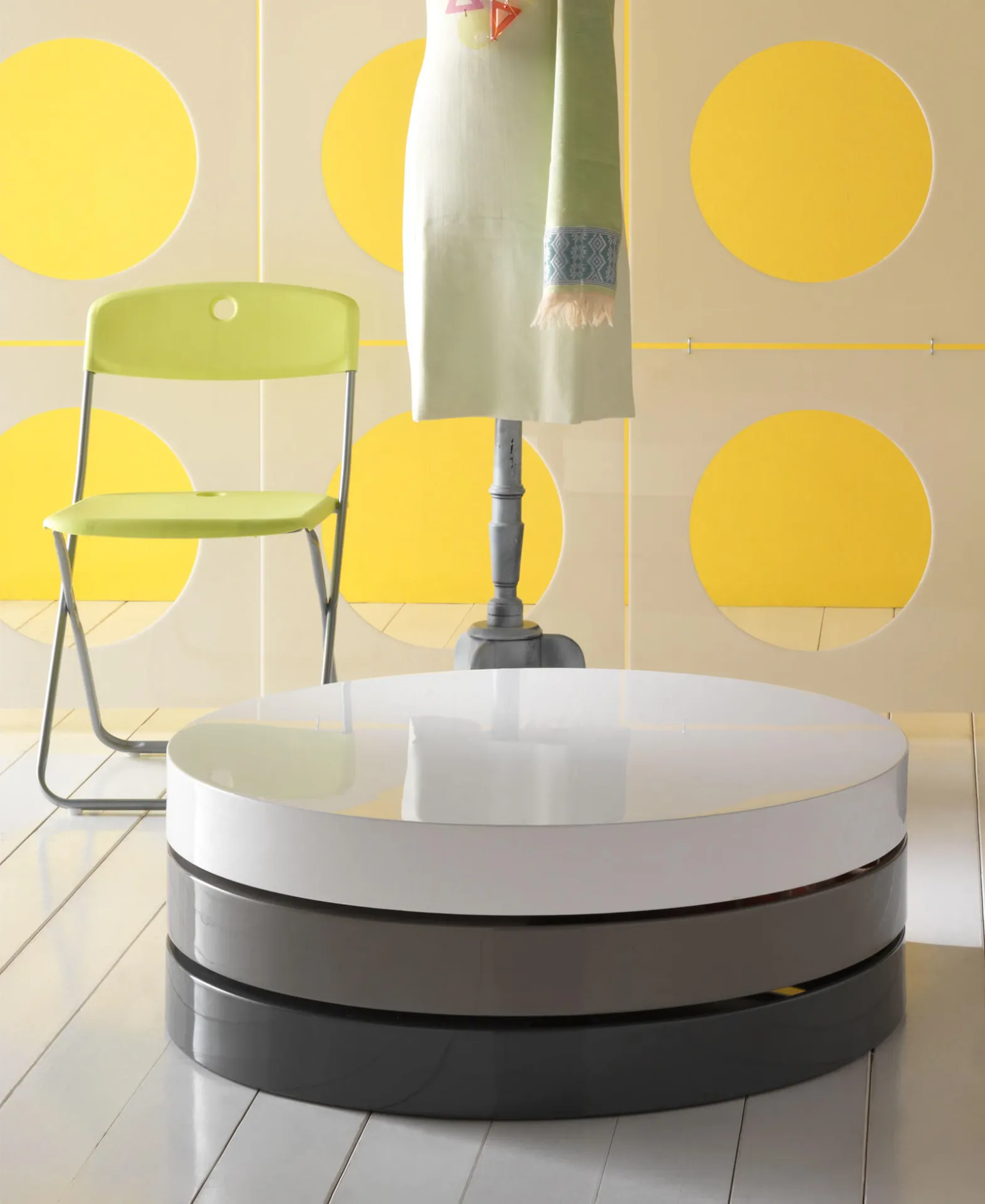 Tavolino rotondo Twist 1 Stones bianco e grigio davanti a una parete gialla