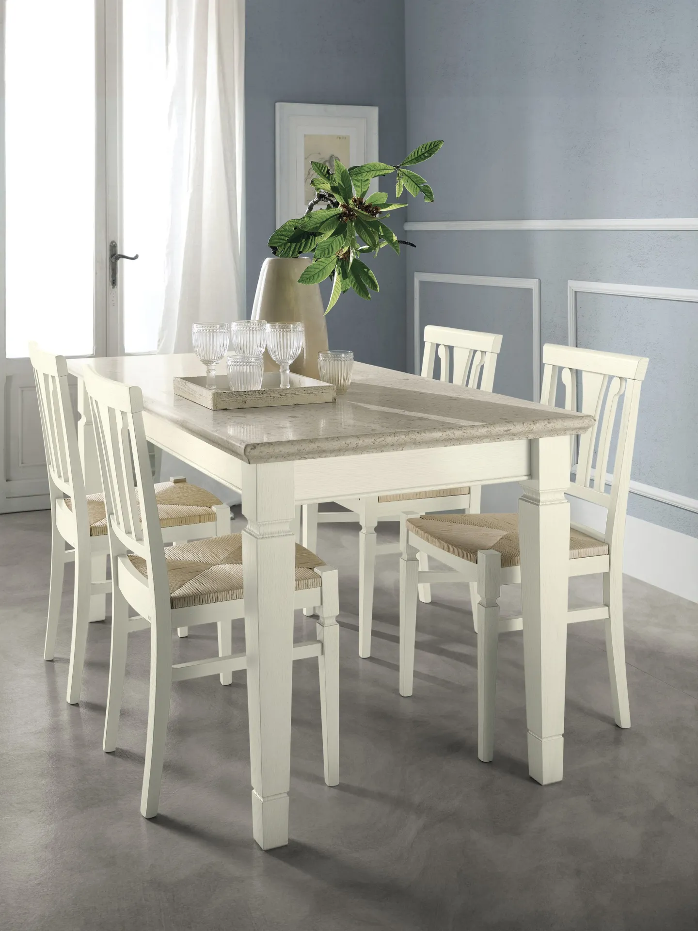 Tavolo Corinne Scavolini bianco con quattro sedie coordinate vicino a una finestra