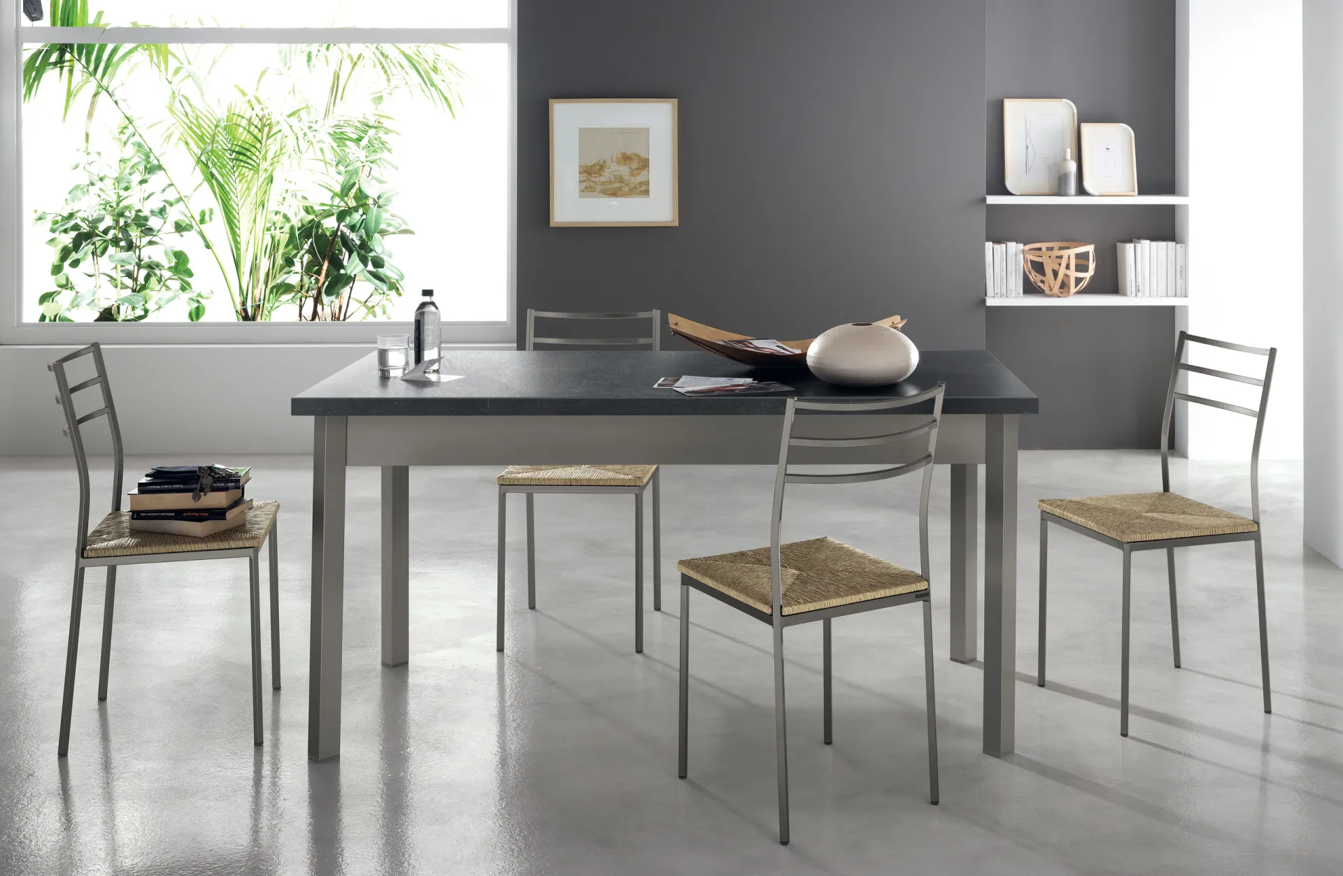 Tavolo Duetto Scavolini con piano scuro e sedie in metallo con seduta impagliata in una cucina luminosa