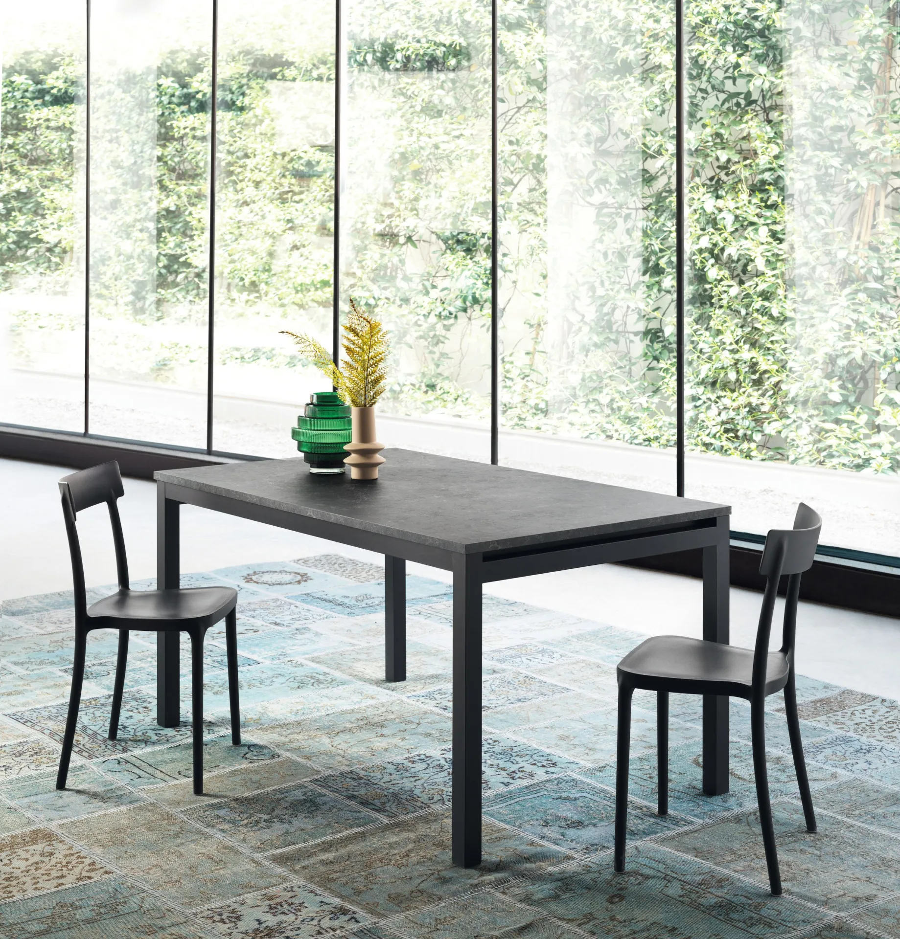 Tavolo Gulliver Scavolini allungato con piano scuro e sedie nere su tappeto
