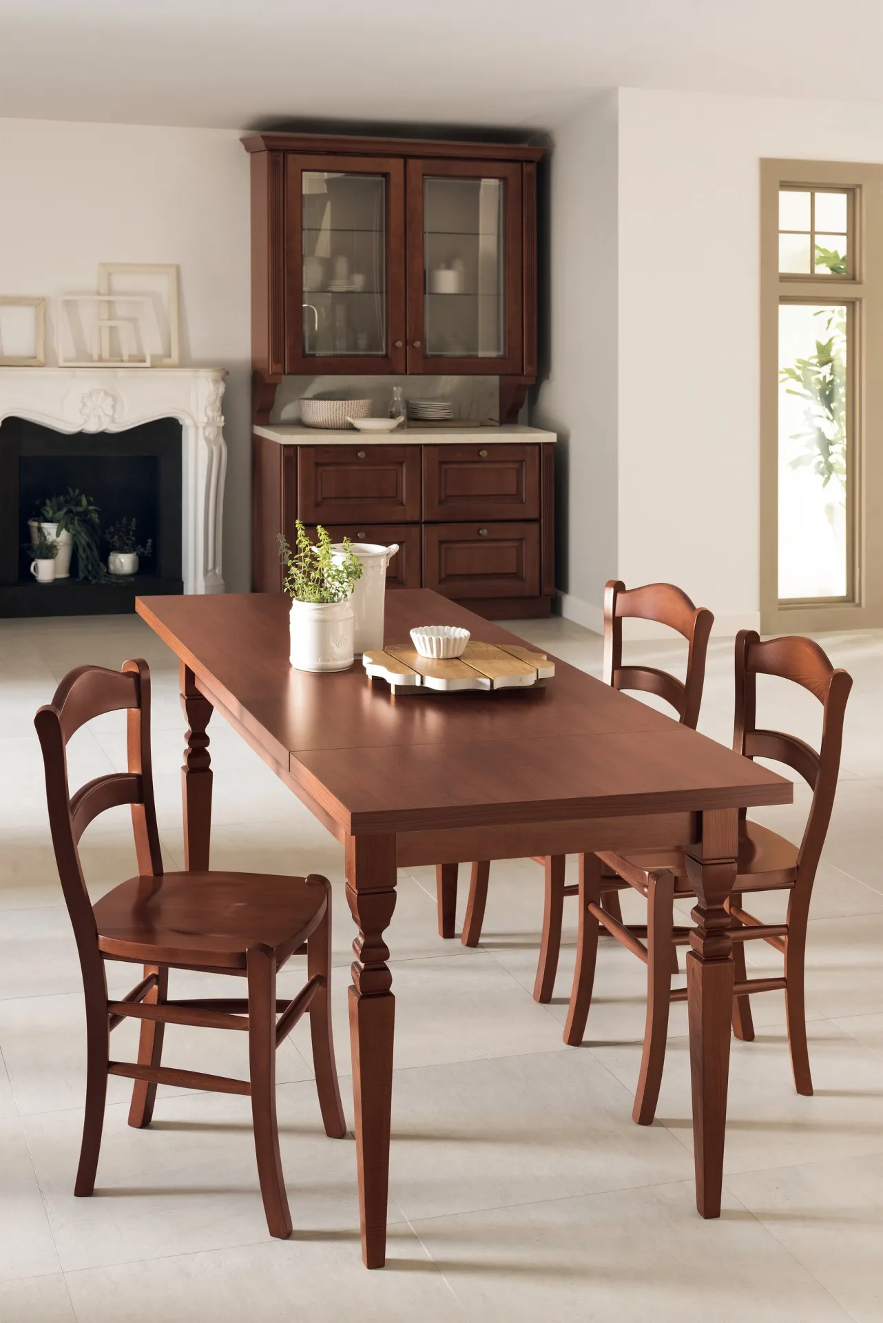 Tavolo Margot Scavolini in tinta legno con sedie in legno e credenza sullo sfondo