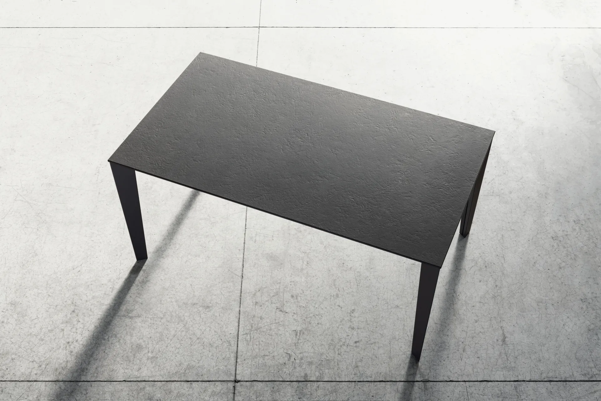 Tavolo Mary Scavolini visto dall'alto, con piano in Abitum grigio scuro su un pavimento chiaro