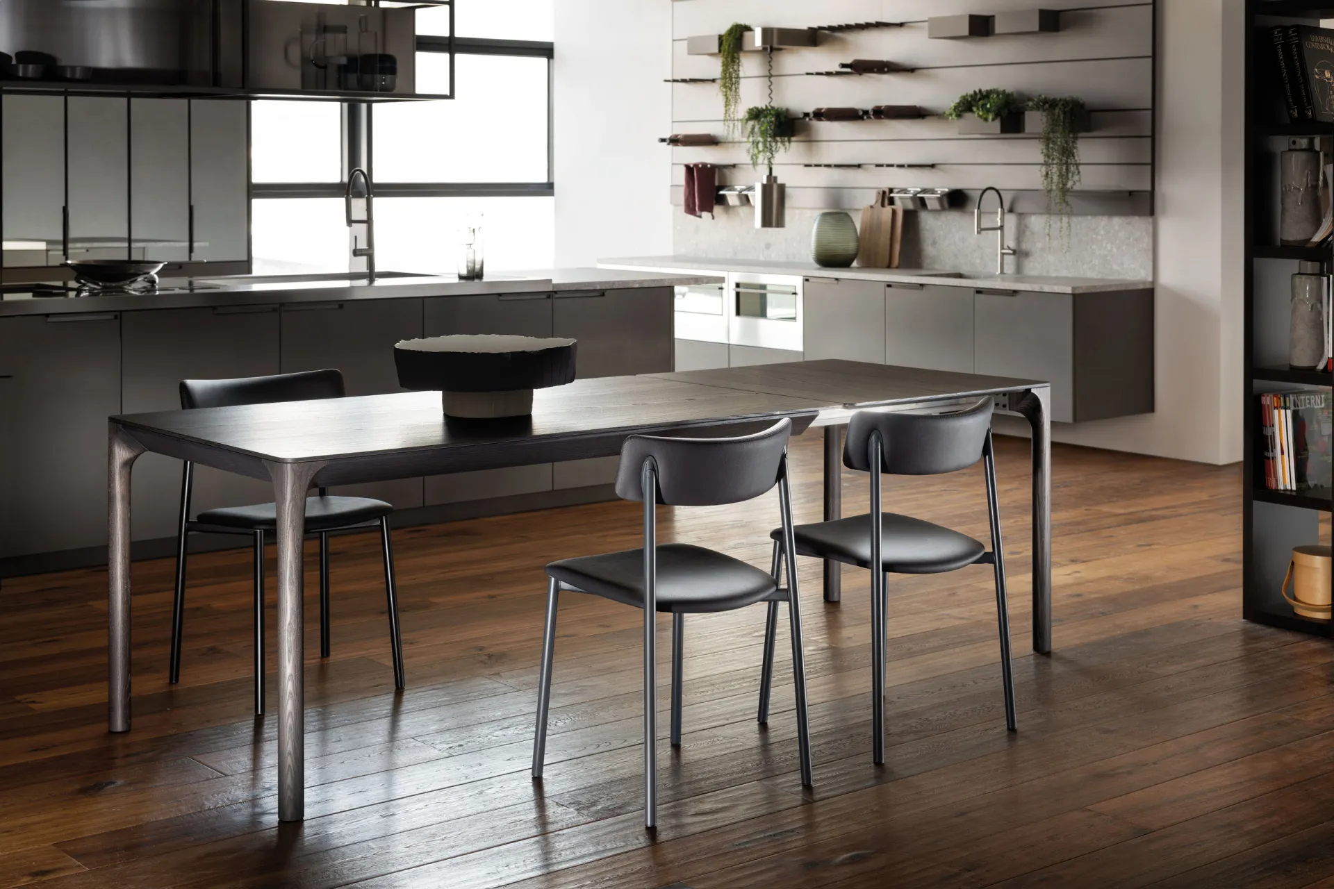 Tavolo Kei Scavolini in frassino scuro con sedie nere in una cucina con parete attrezzata