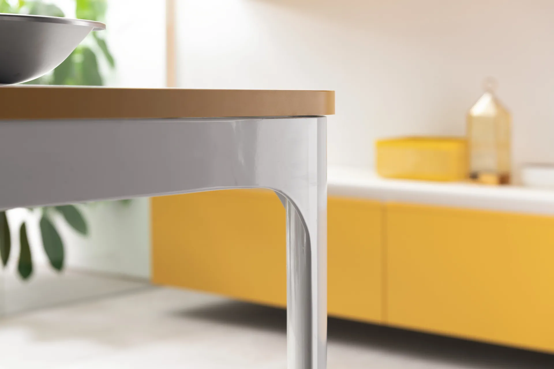 Dettaglio del tavolo Dandy Plus Scavolini con piano effetto legno e gamba bianca curva