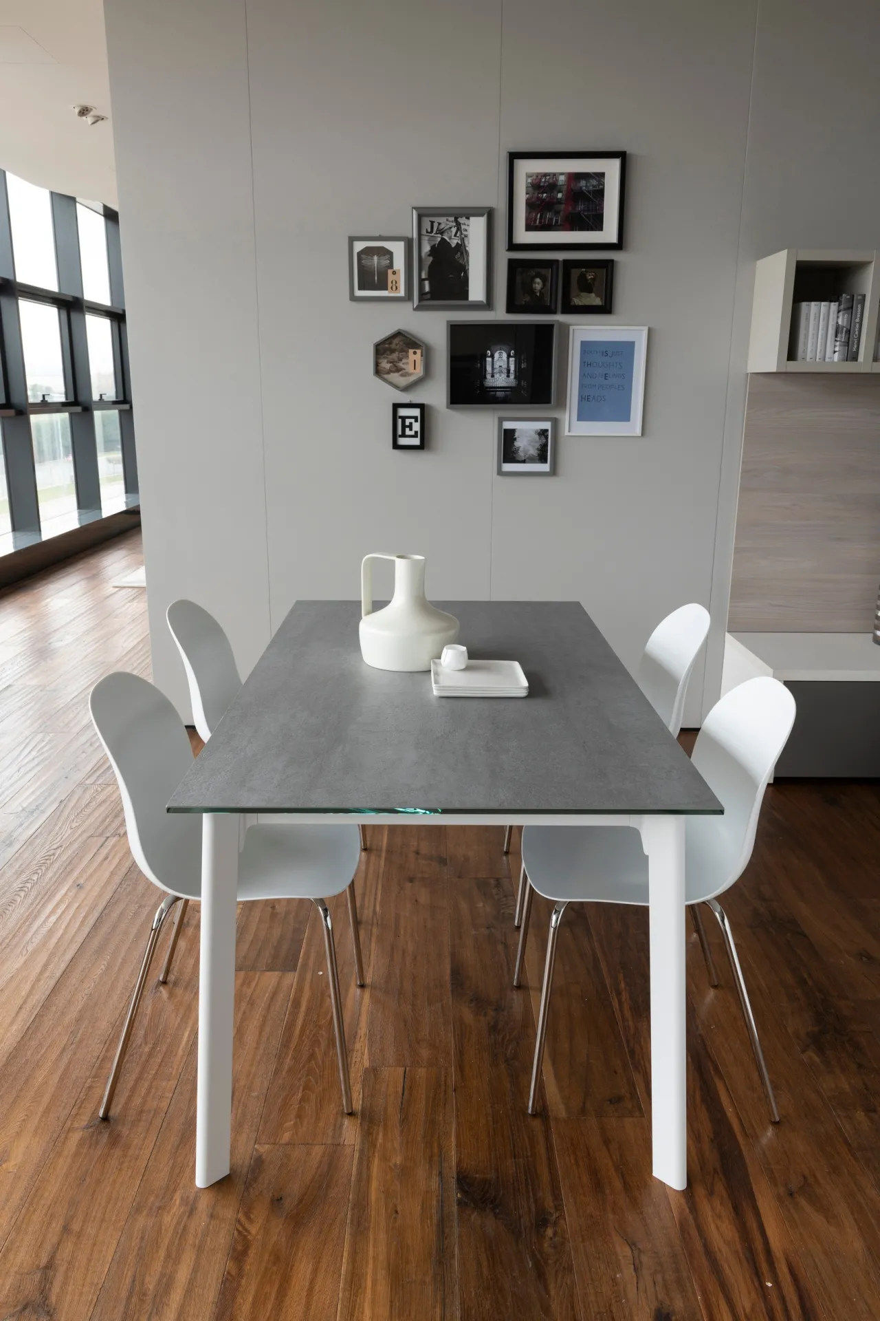 Tavolo Norwegian Scavolini bianco con piano grigio e sedie bianche su parquet