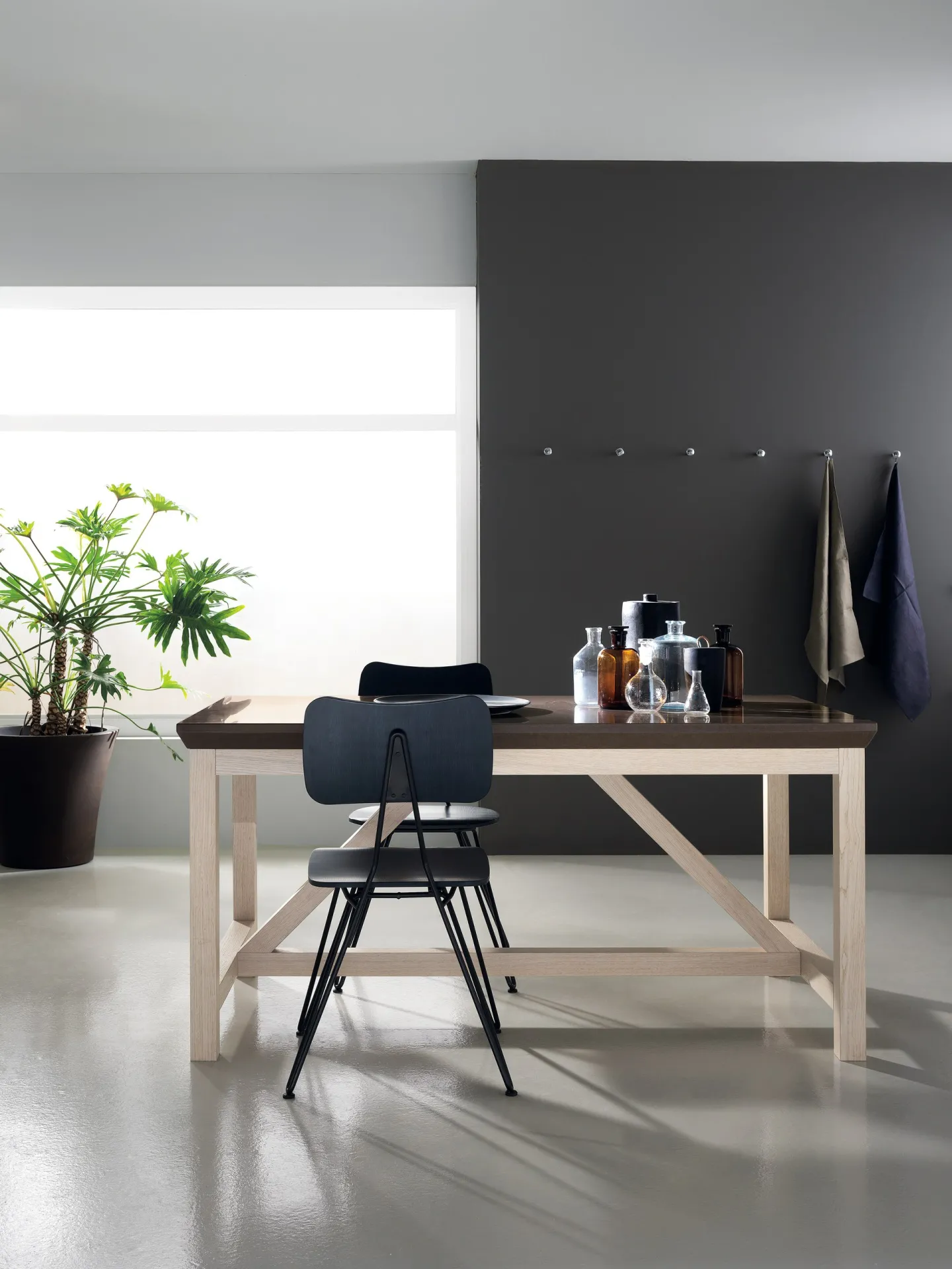 Social Floating Table Scavolini con base in rovere chiaro e sedia nera in una cucina