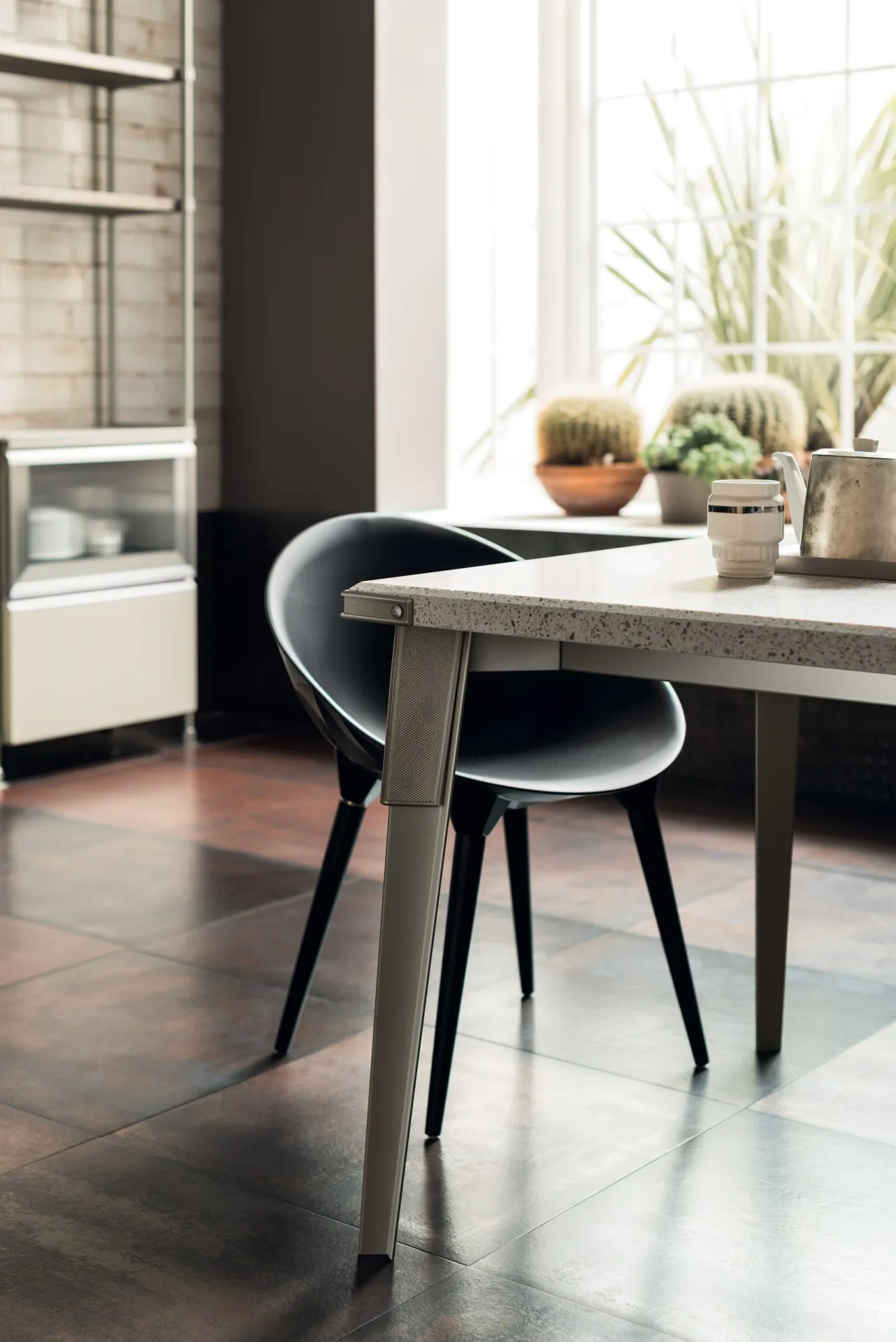 Open Workshop Table Scavolini con piano chiaro e sedie scure in una cucina di gusto industriale