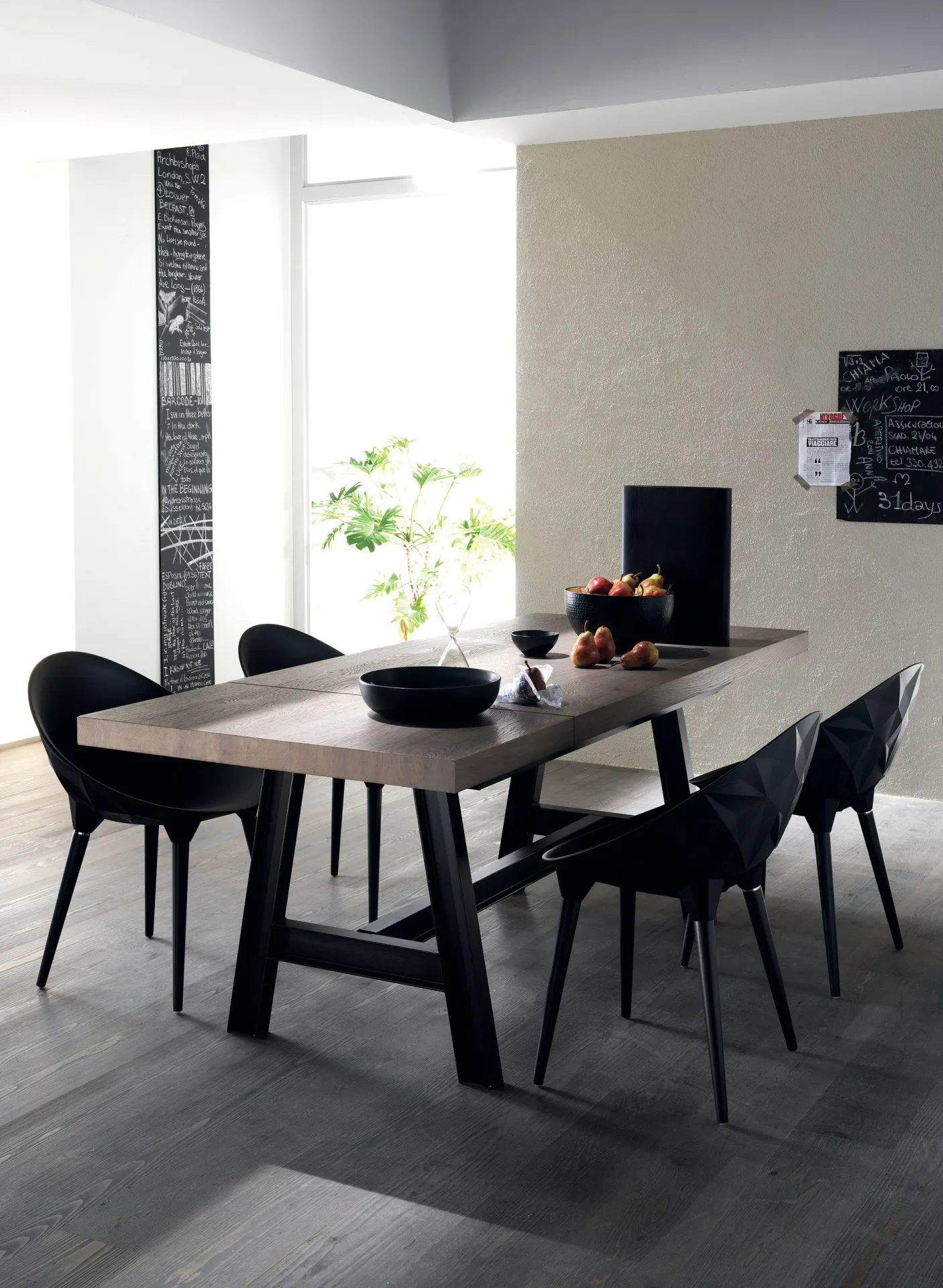 Misfit Table Scavolini con piano scuro e sedie nere avvolgenti in una cucina luminosa