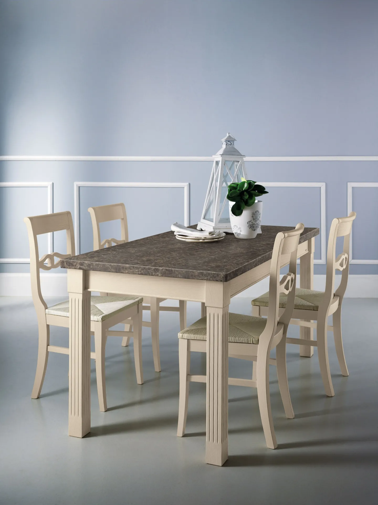 Tavolo Baltimora Scavolini avorio con piano effetto pietra e sedie coordinate su parete azzurra
