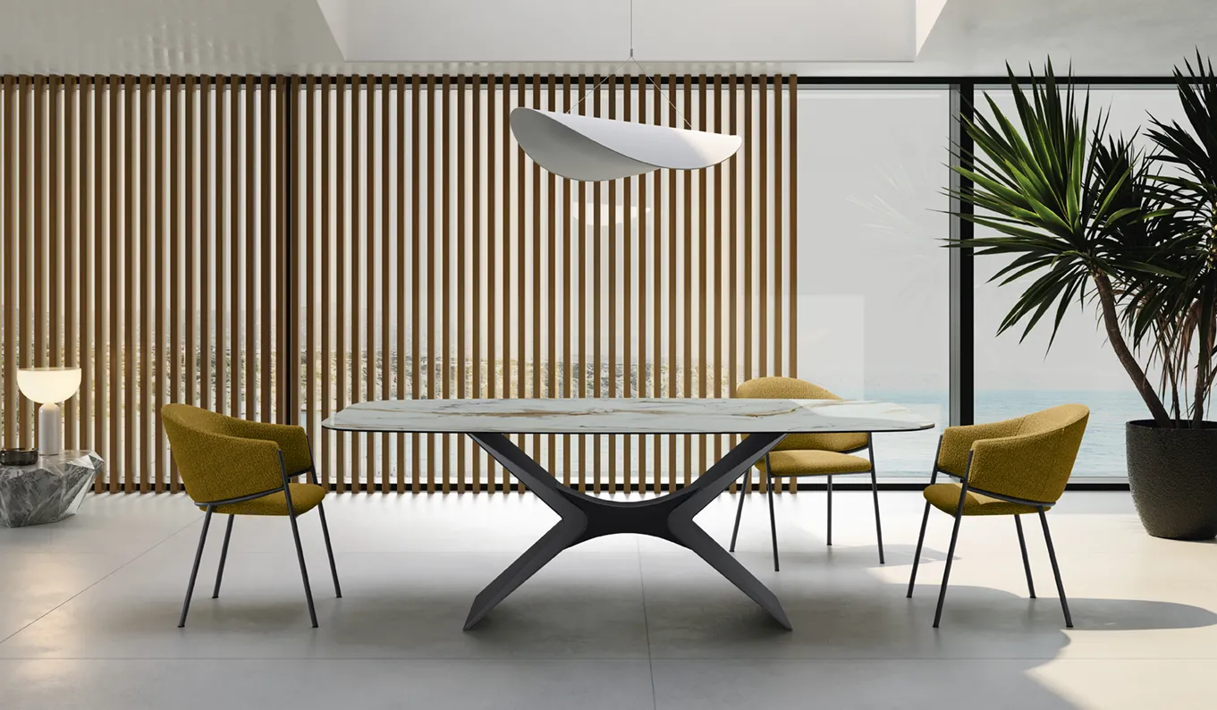 Tavolo Atlas Stones con piano Calacatta oro lucido e base antracite in una sala con parete a listelli di legno