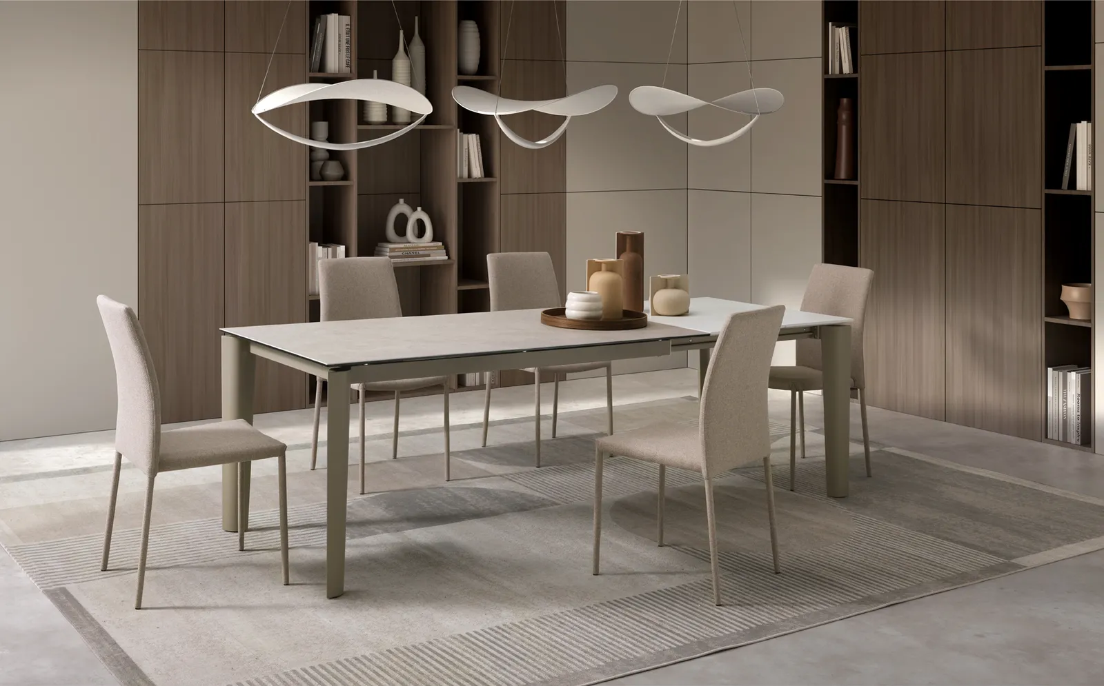 Tavolo allungabile Horus Stones color sabbia in una sala da pranzo con sedie chiare e lampade a sospensione