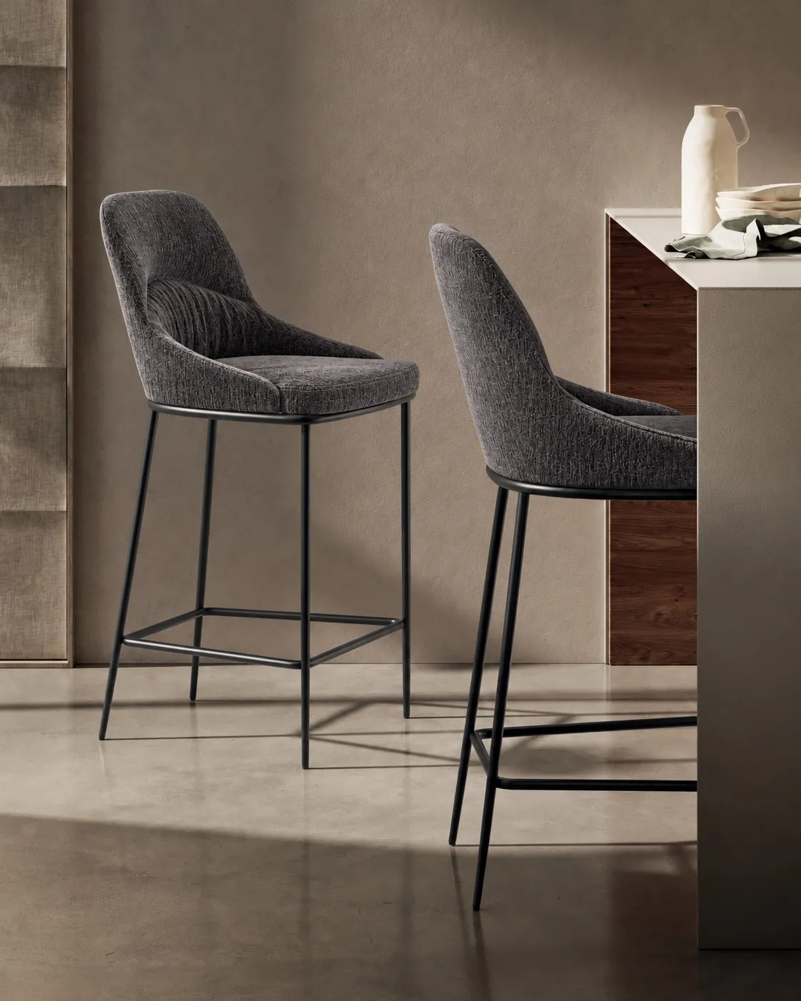 Sgabelli Ginevra Stones grigio scuro con gambe nere accostati a un bancone
