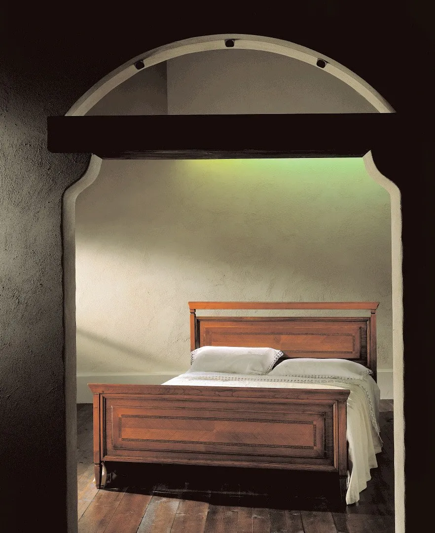 Letto con bugna Ottocento Avenanti in ciliegio sotto un arco, con pediera a pannello
