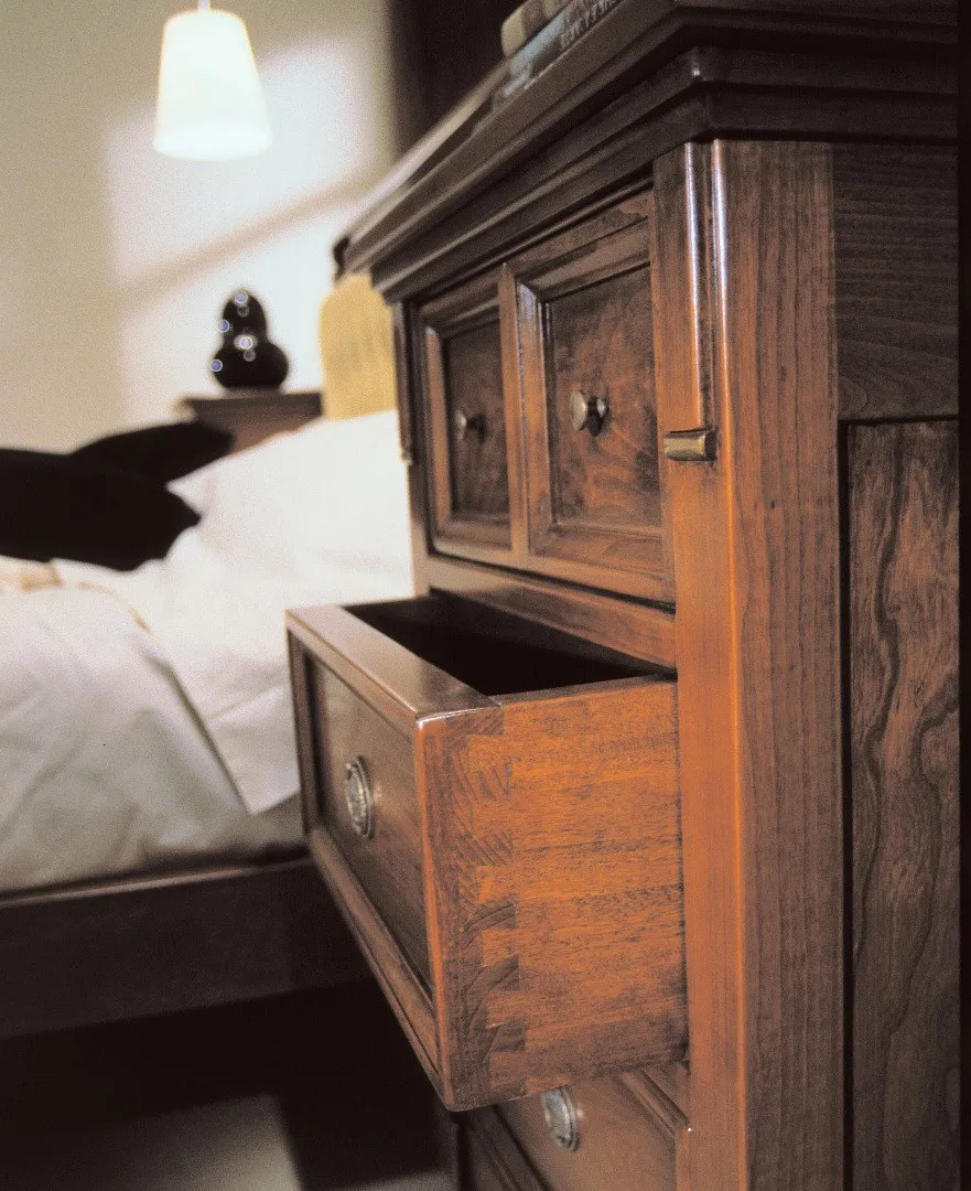 Particolare del letto Ottocento Avenanti con testata imbottita e cassetto del comodino aperto
