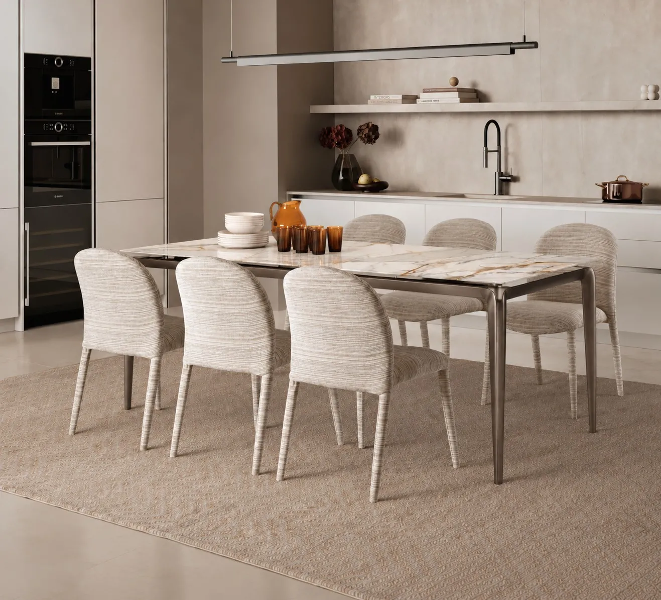 Tavolo Rail Stones Calacatta oro con struttura bronzo e sedie chiare in una cucina
