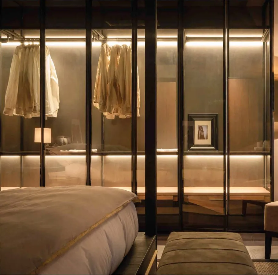 Armadio ControLuce Bernazzoli con ante in vetro bronzo e appenderie illuminate accanto al letto