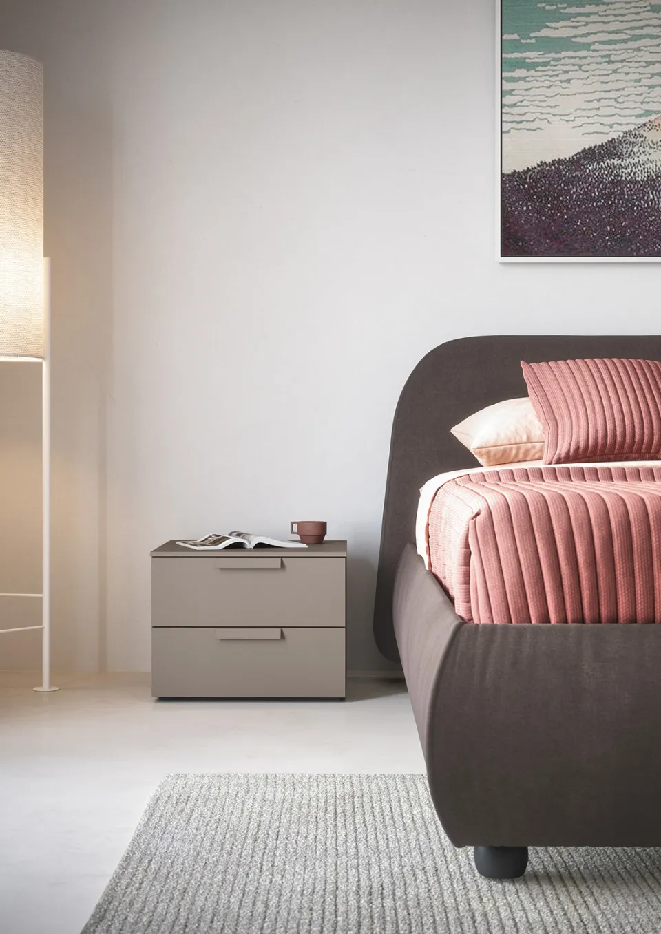 Comodino Oslo Cinquanta3 grigio chiaro accanto a un letto imbottito