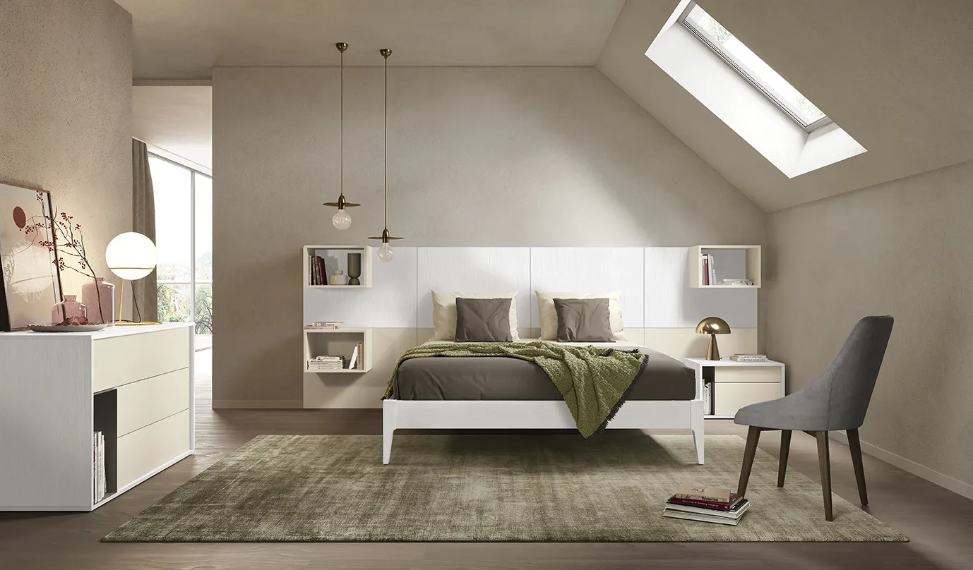 Letto con boiserie Pepita Colombini bianco con contenitori sospesi in una mansarda con lucernario